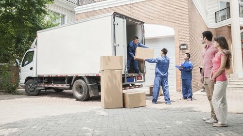 Group of movers putting boxes in a truck