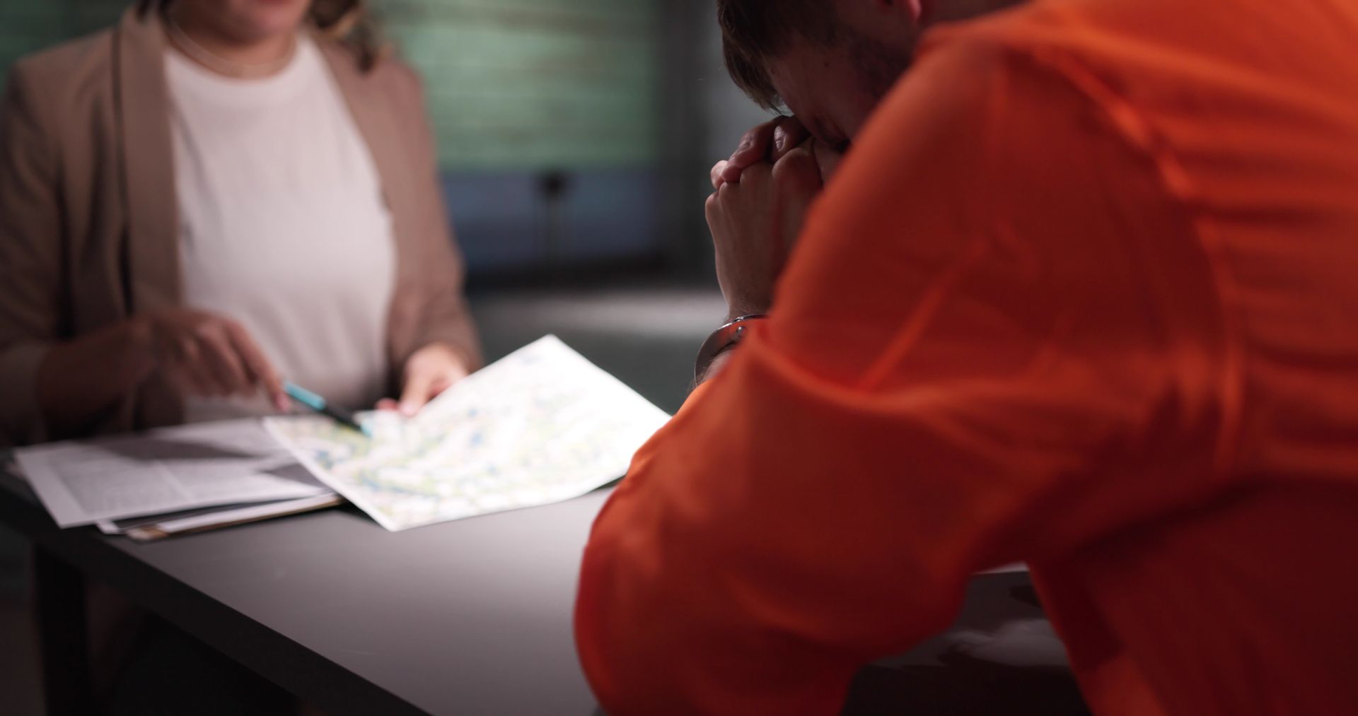 Female criminal defense attorney interviewing accused prisoner.