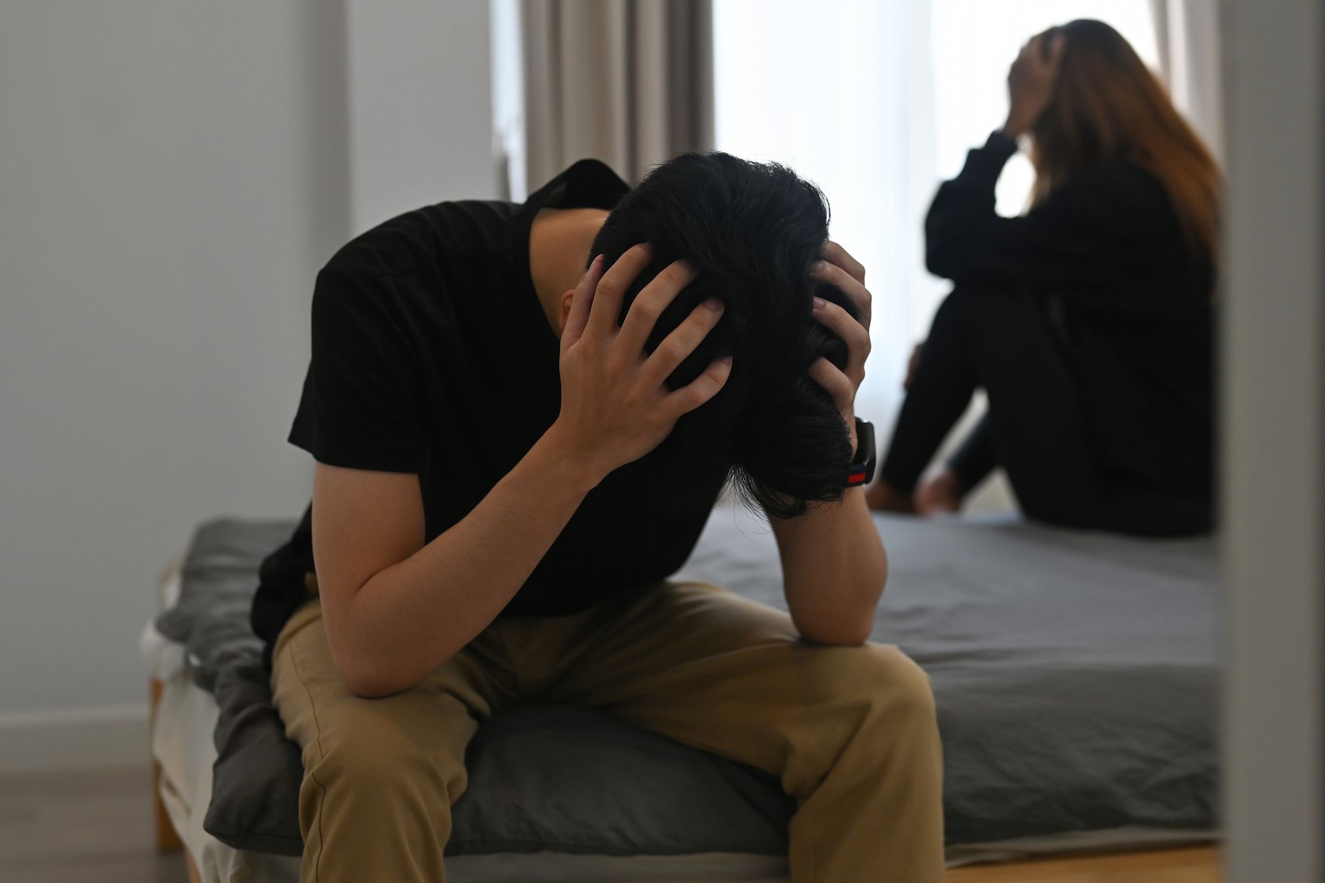 A woman is covering her face with her hands.