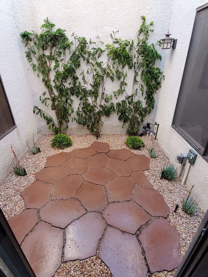 A house with a walkway leading to it and a brick wall