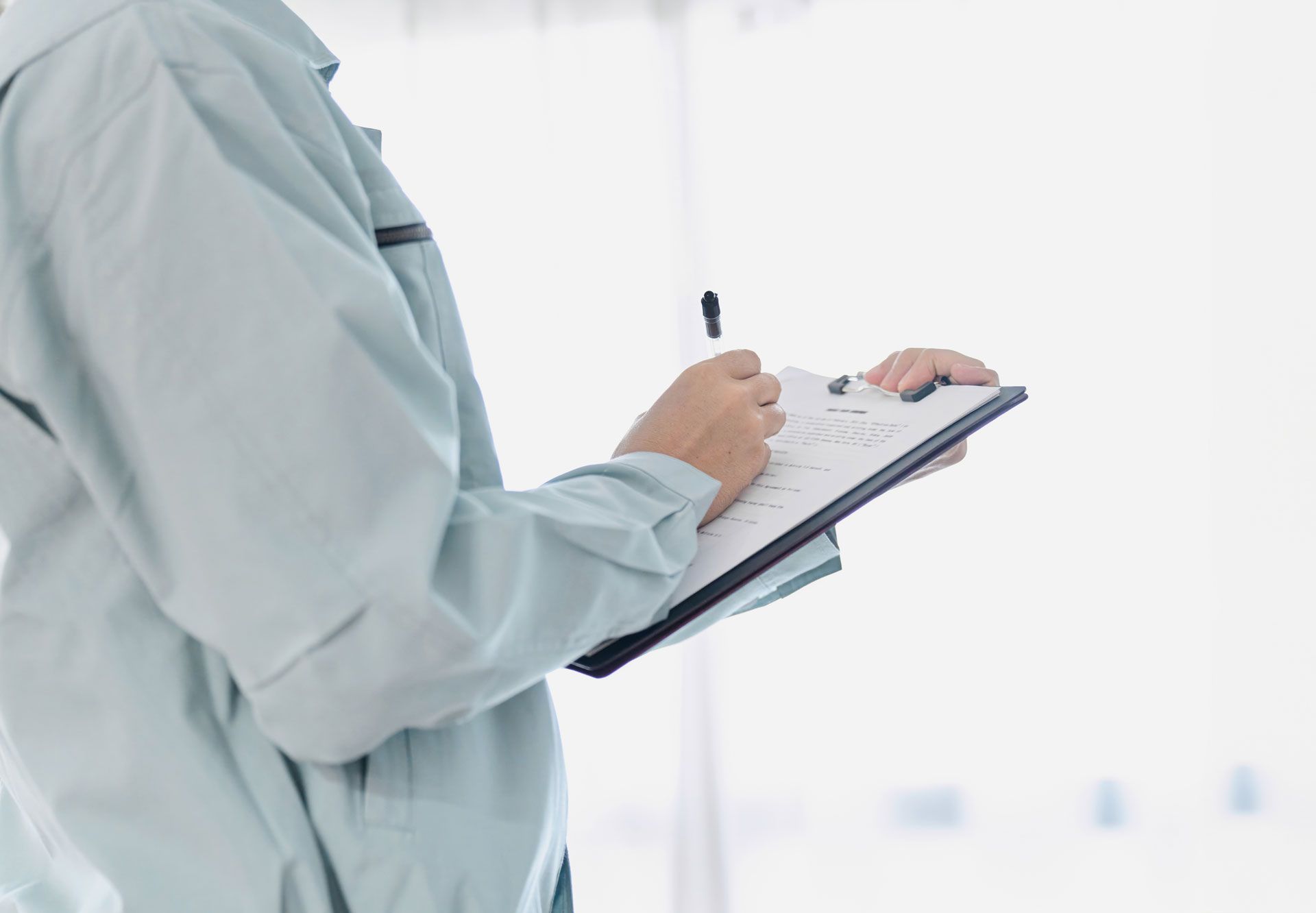 A person is holding a clipboard and writing on it.