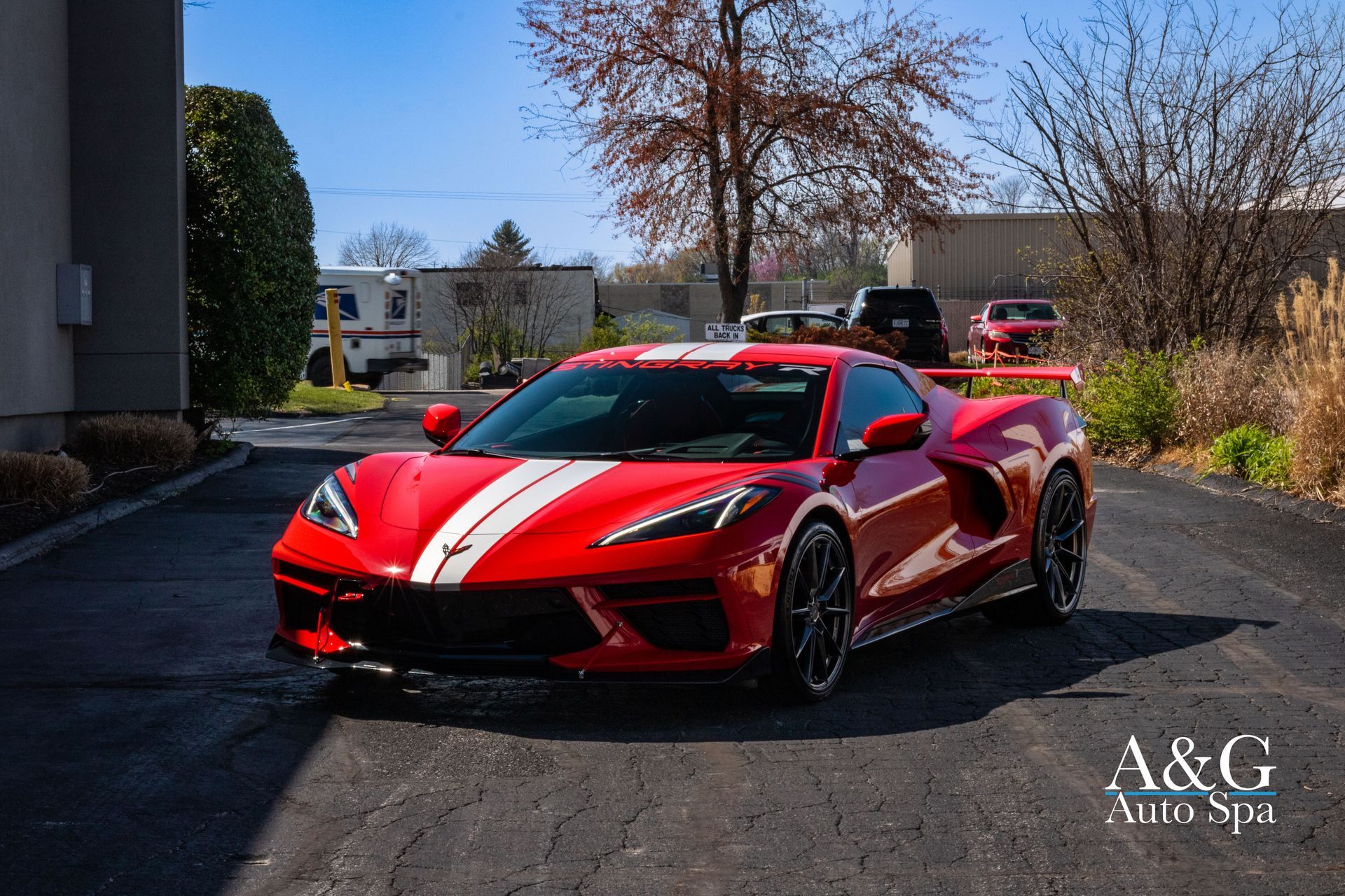 A red sports car is parked in a parking lot.