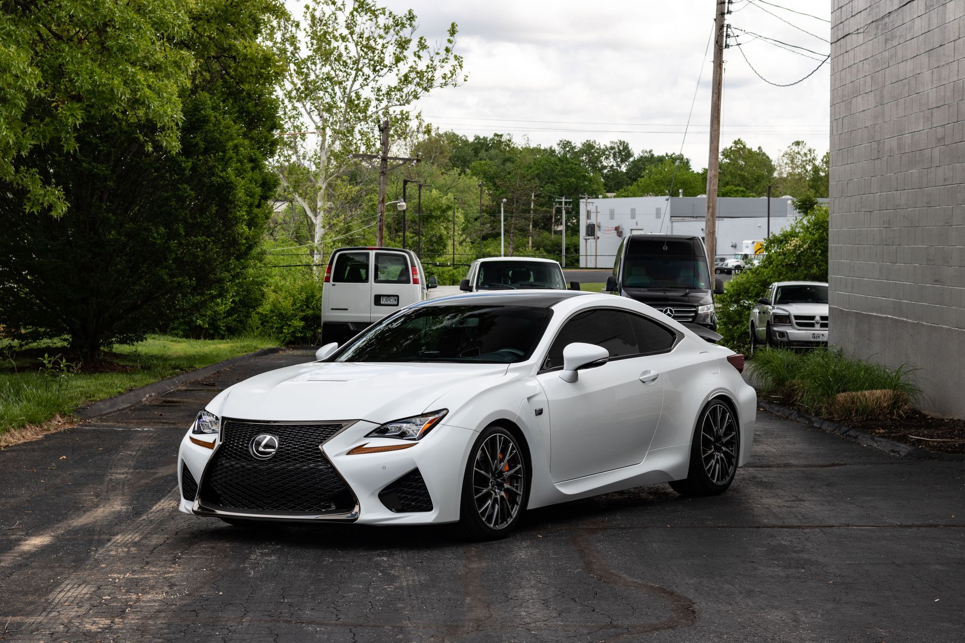 A white lexus rc f sport is parked in a parking lot.