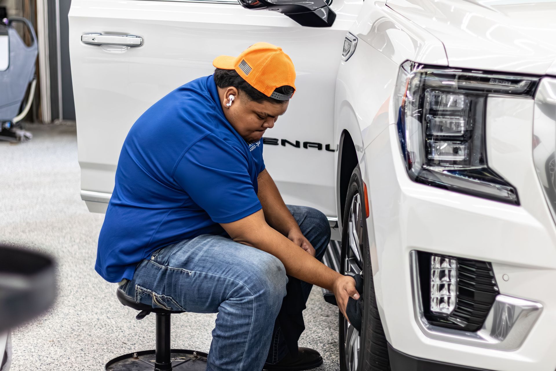 A group of men are working on a car in a garage.