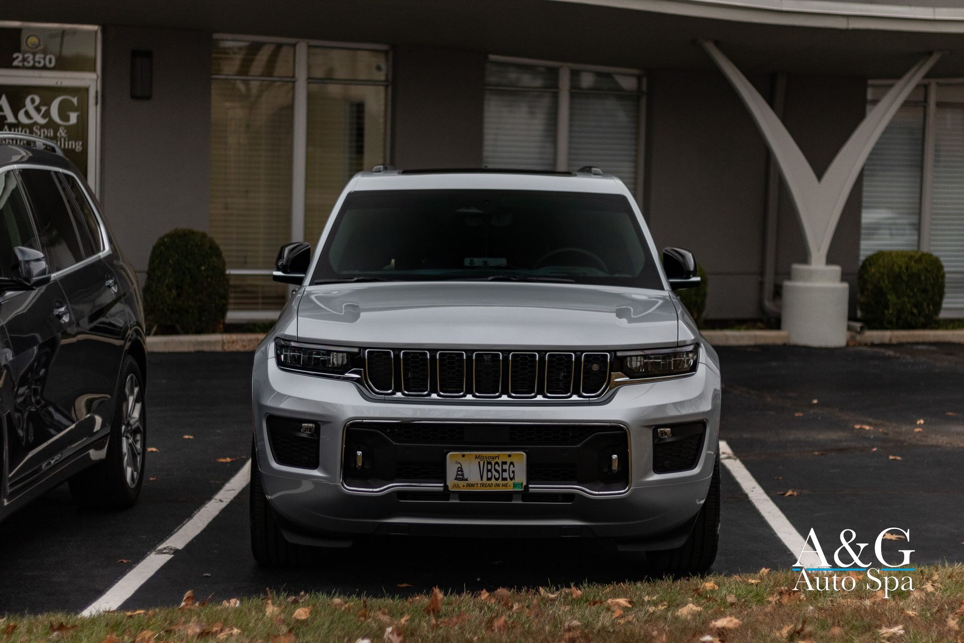 Silver SUV parked in front of a building with a sign for