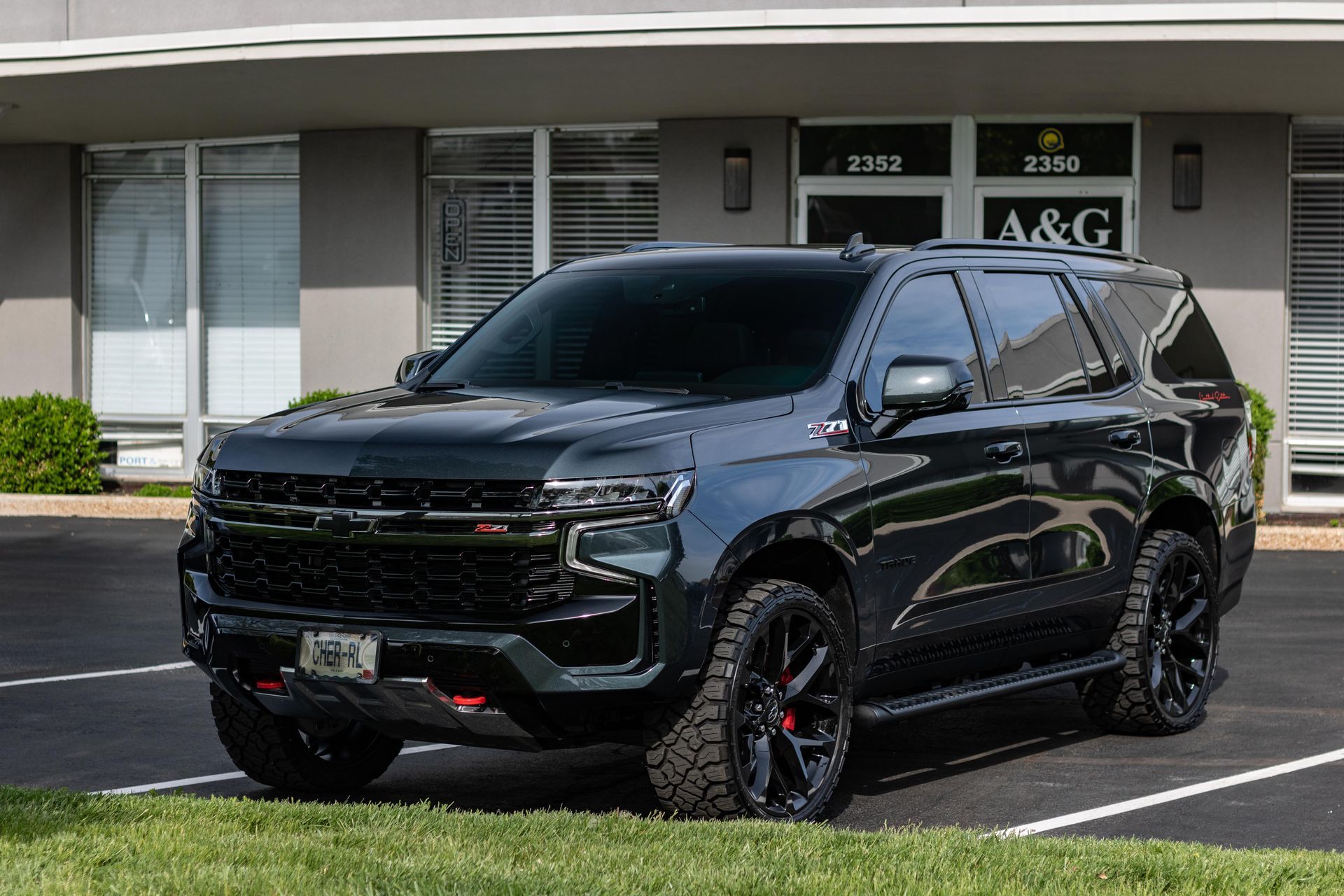 A black suv is parked in a parking lot in front of a building.