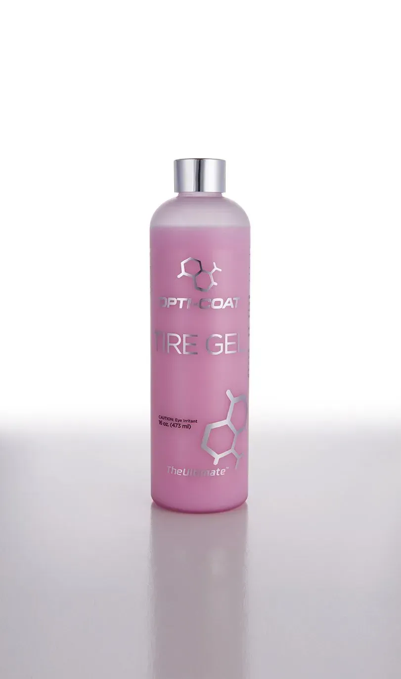 A pink bottle of shampoo is sitting on a white surface.