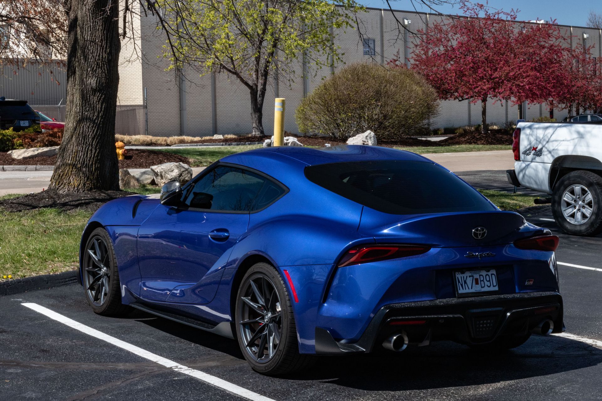A blue toyota supra is parked in a parking lot.