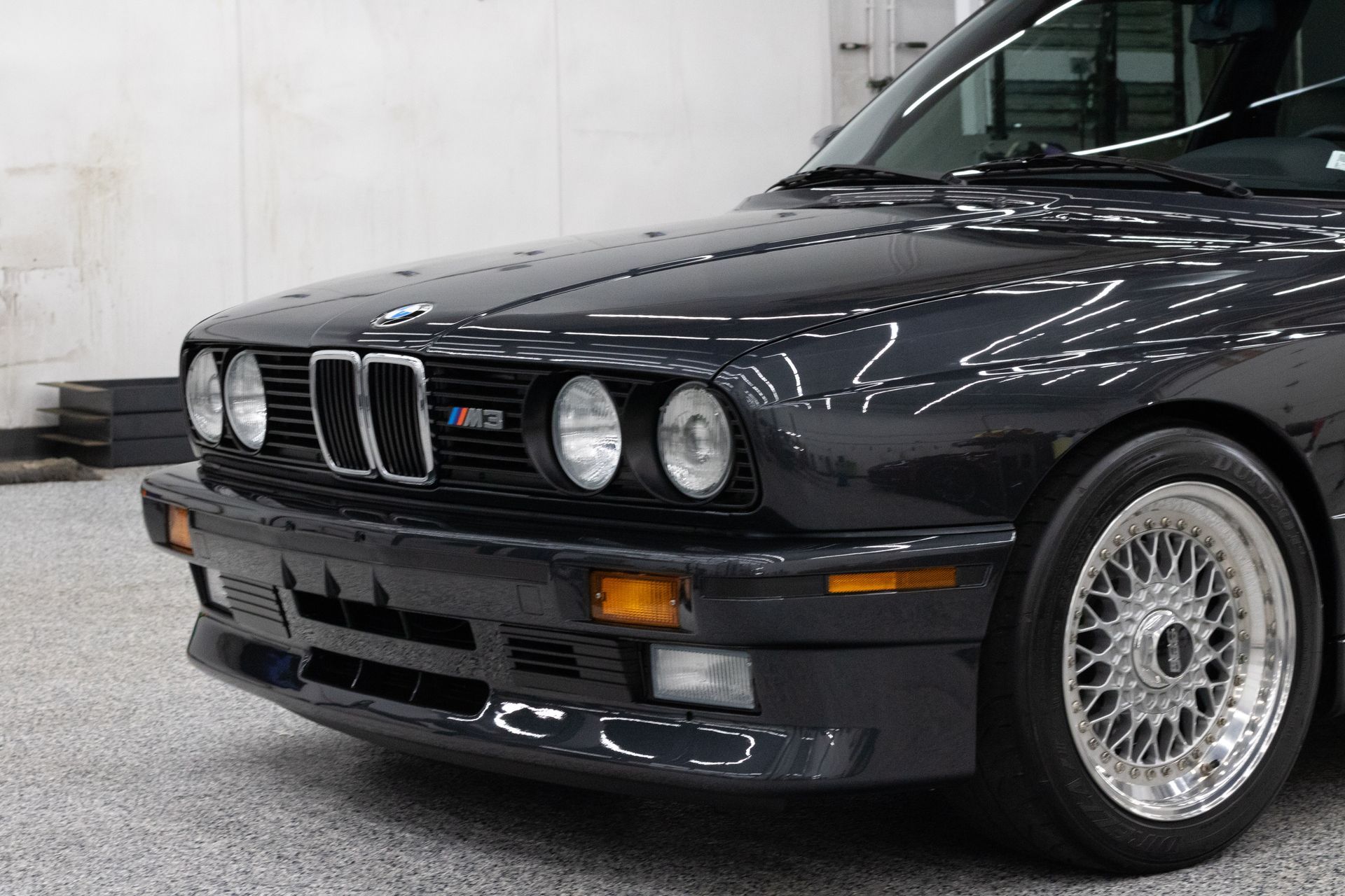 A black bmw m3 is parked in a garage.