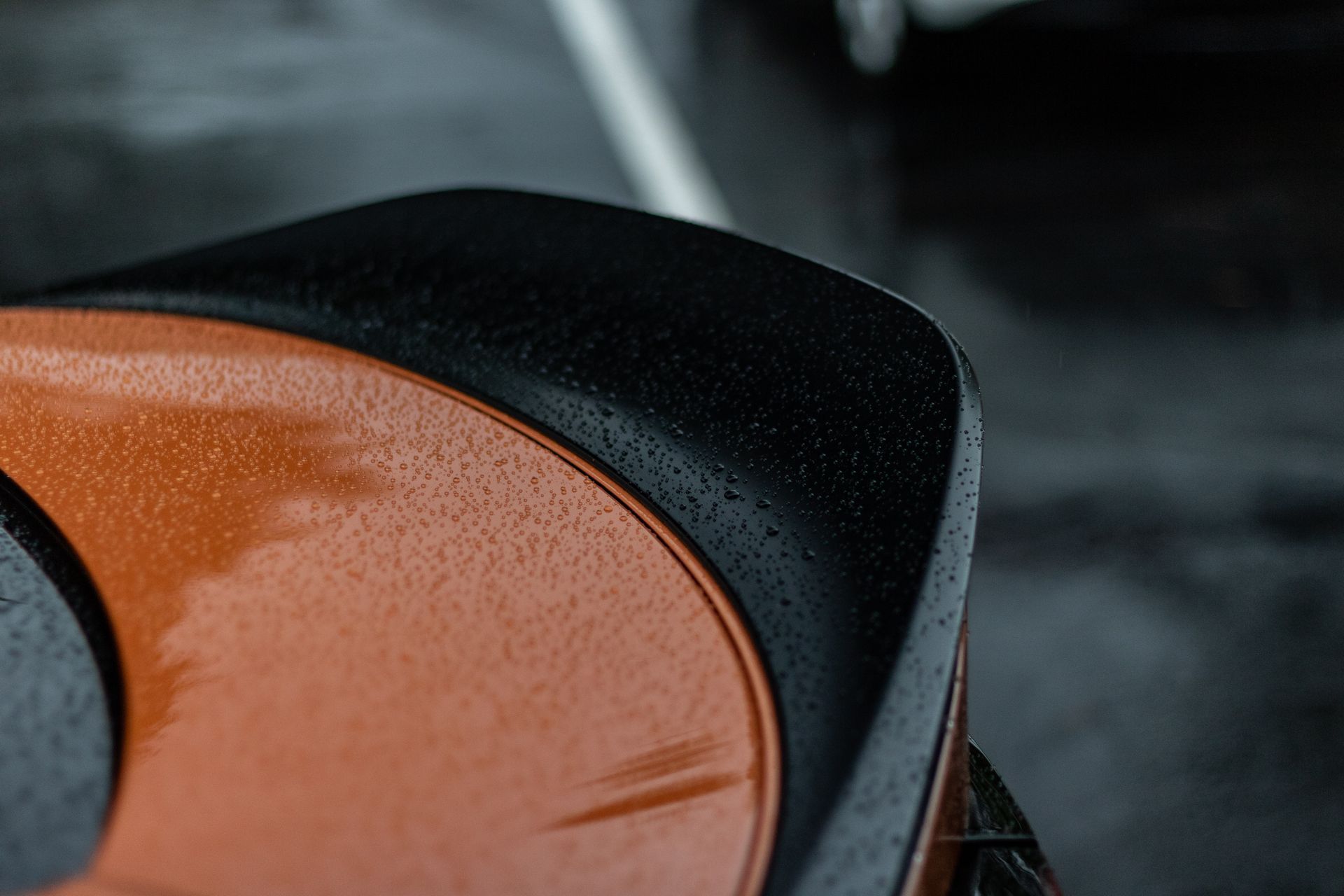 A close up of a car trunk with water drops on it.