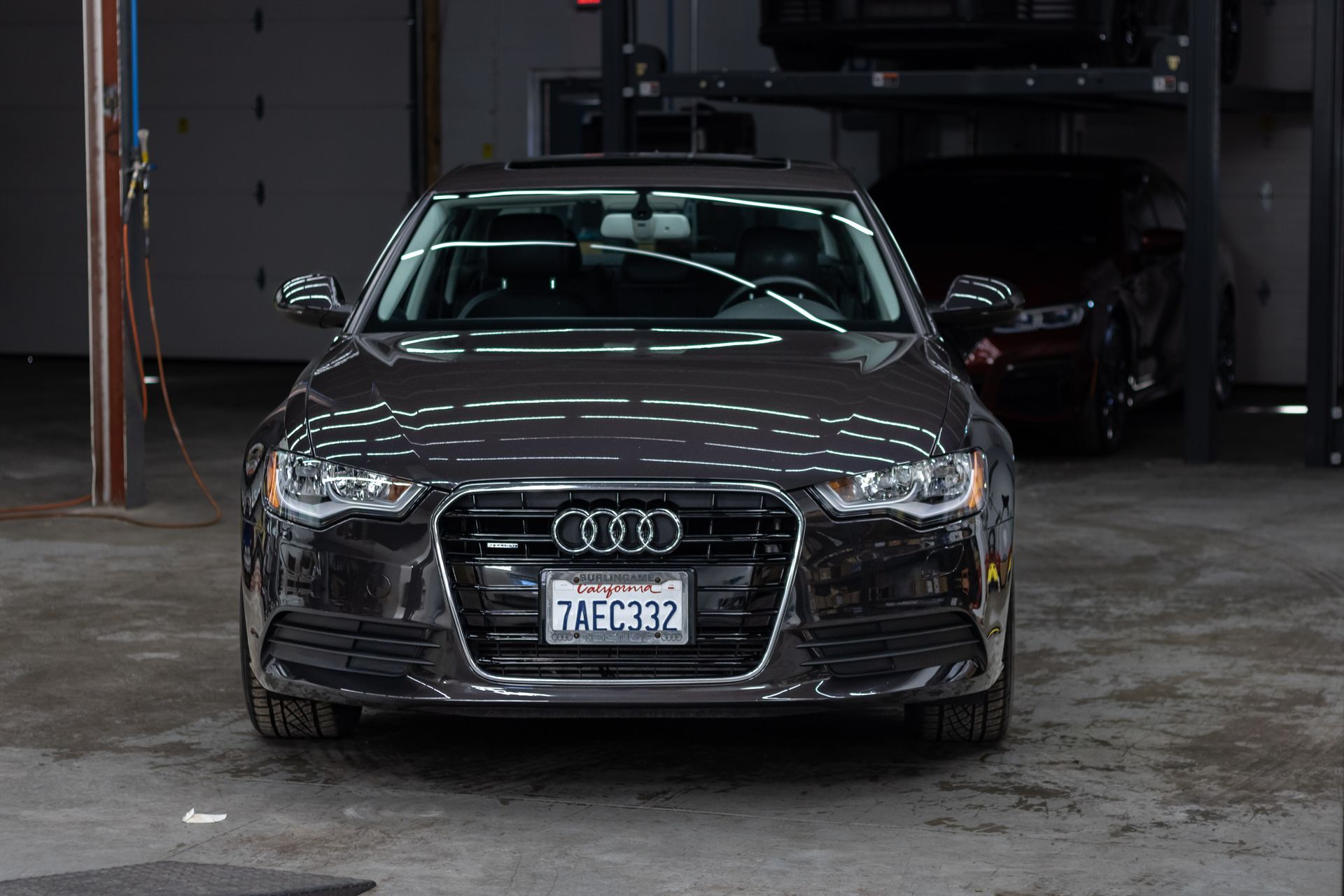 A black audi a6 is parked in a garage.