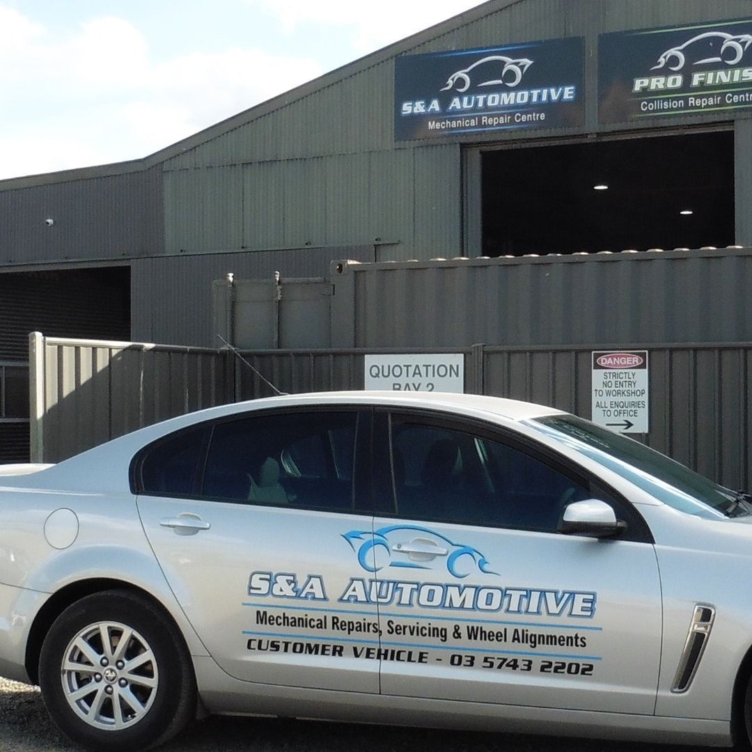 A Man Is Fixing a Brake Disc on A Car in A Garage — S&A Automotive Repairs Pty Ltd In Yarrawonga, VIC