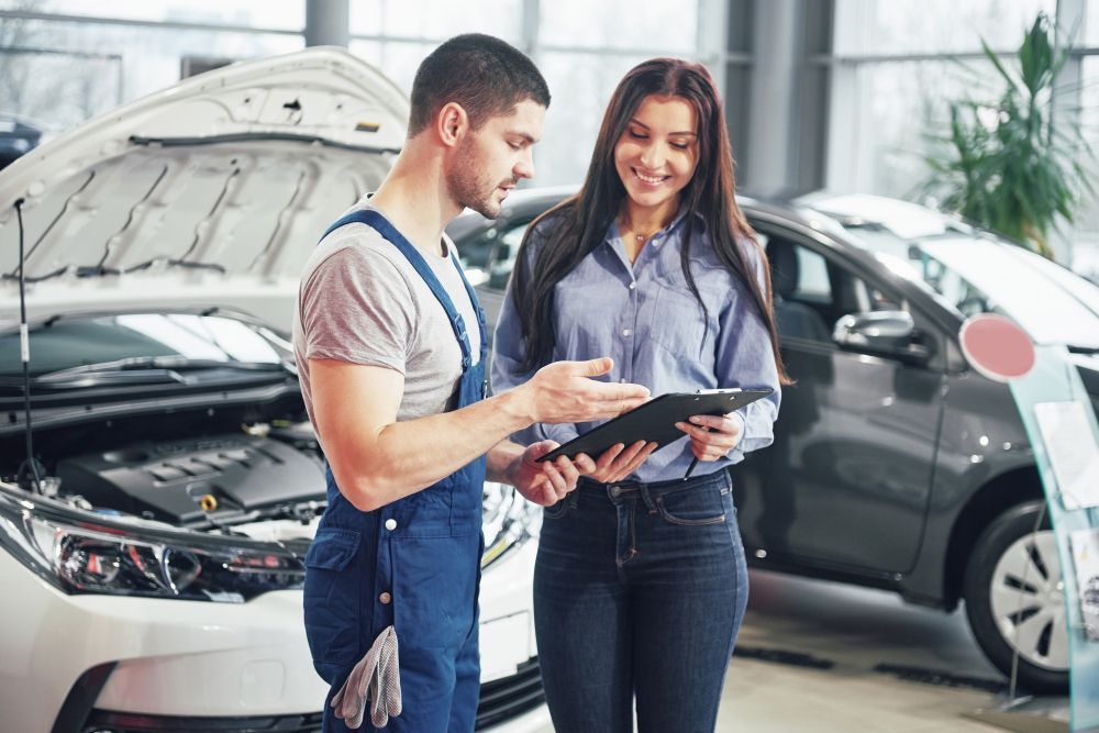 A Mechanic Is Talking To A Woman In A Car Showroom — S&A Automotive Repairs Pty Ltd In Yarrawonga, VIC