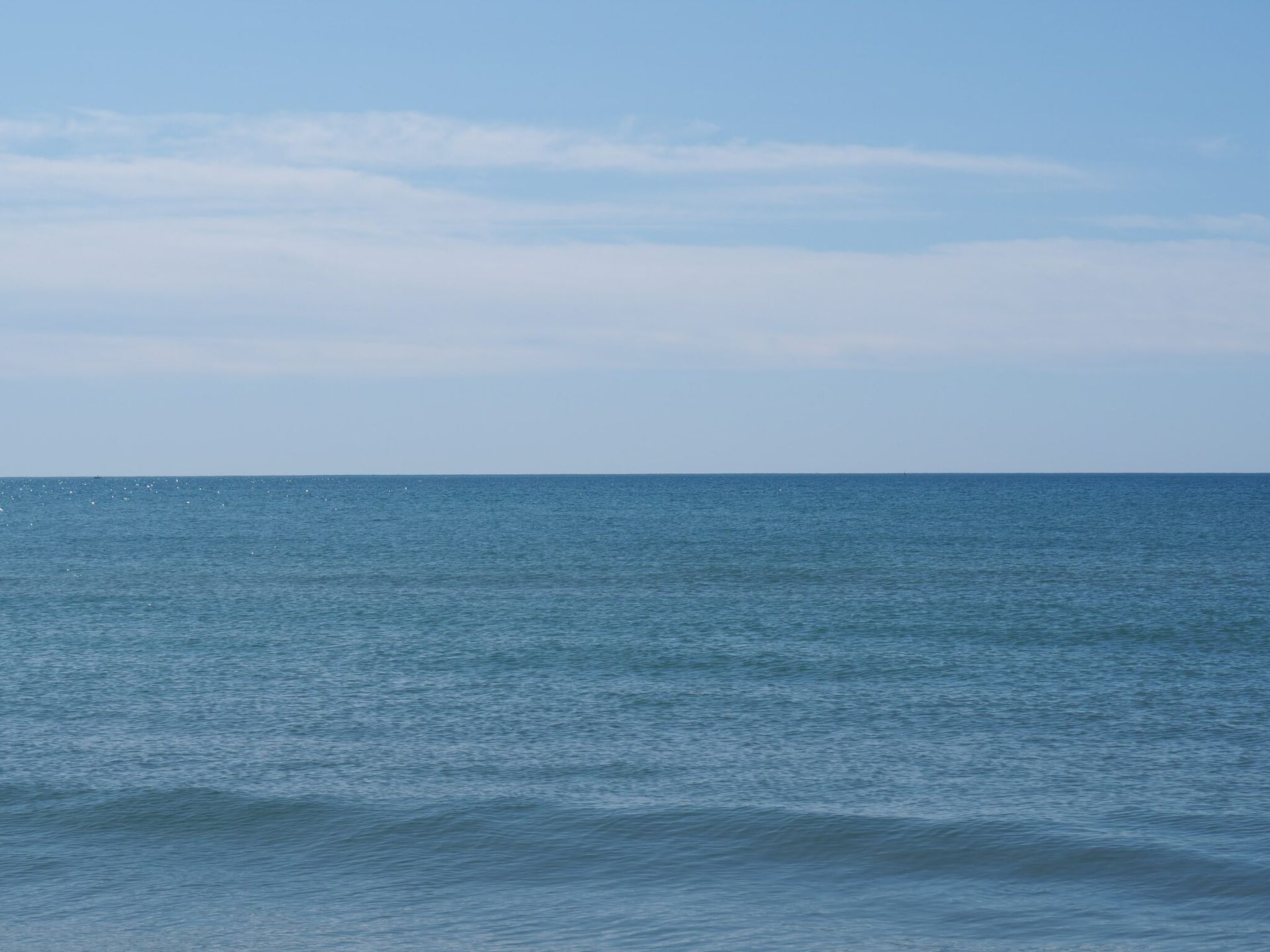 A large body of water with a blue sky in the background.