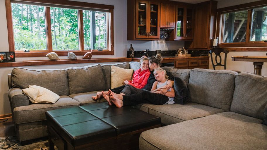 A family is sitting on a couch in a living room.
