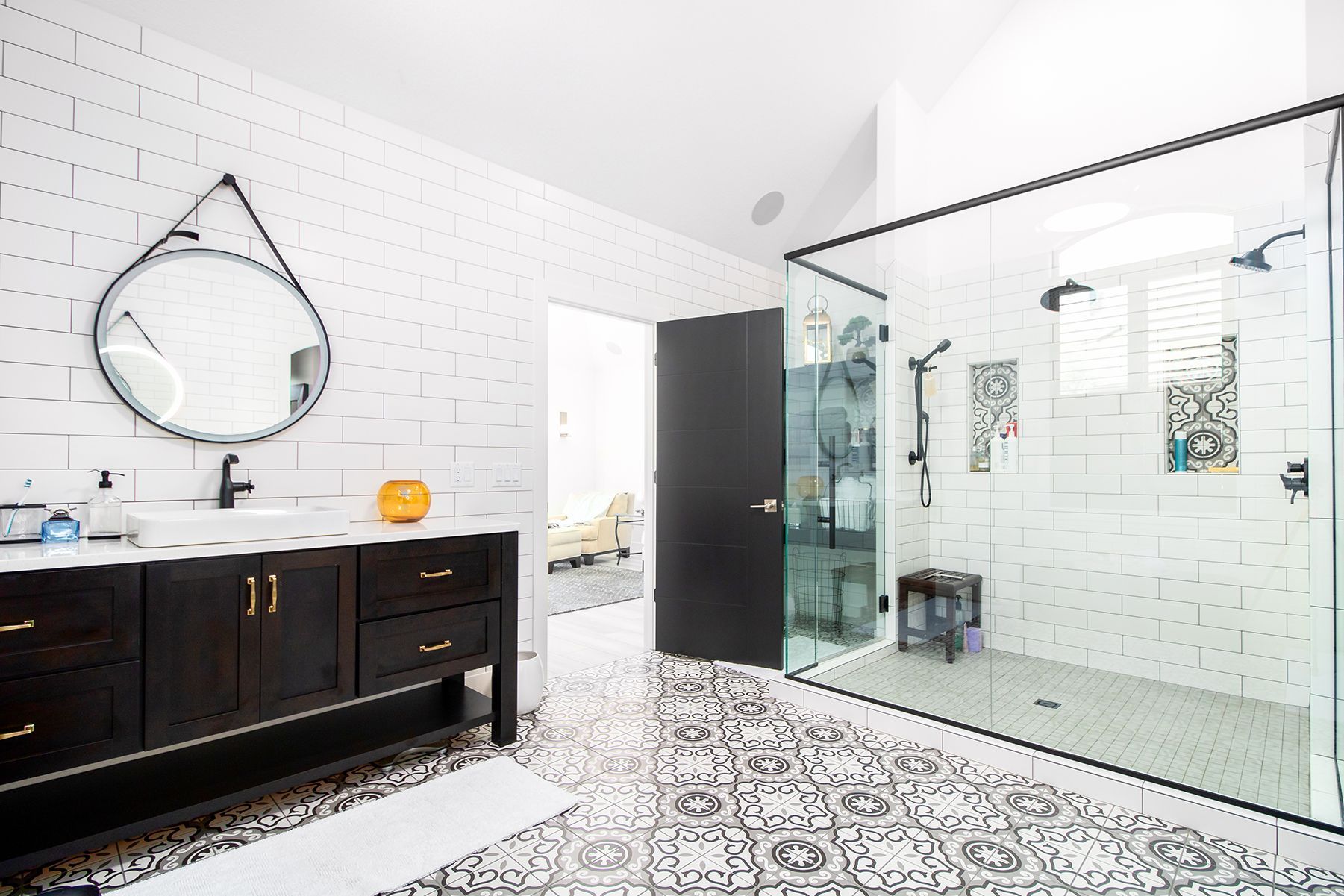 A bathroom with a walk in shower , sink and mirror.