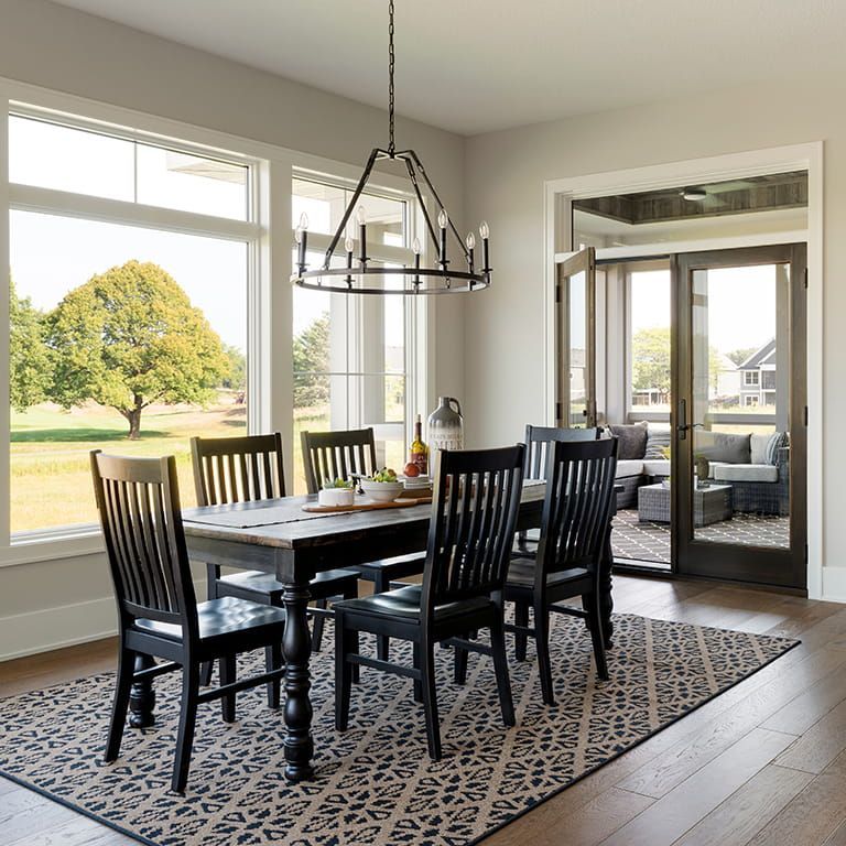 A dining room with a table and chairs and a rug