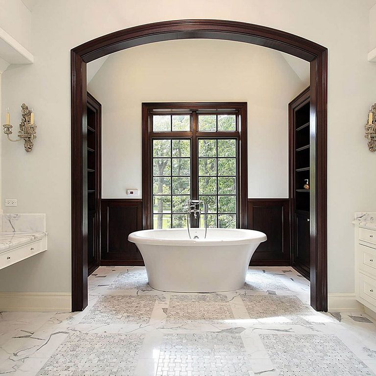 A bathtub is sitting in a bathroom next to a window.