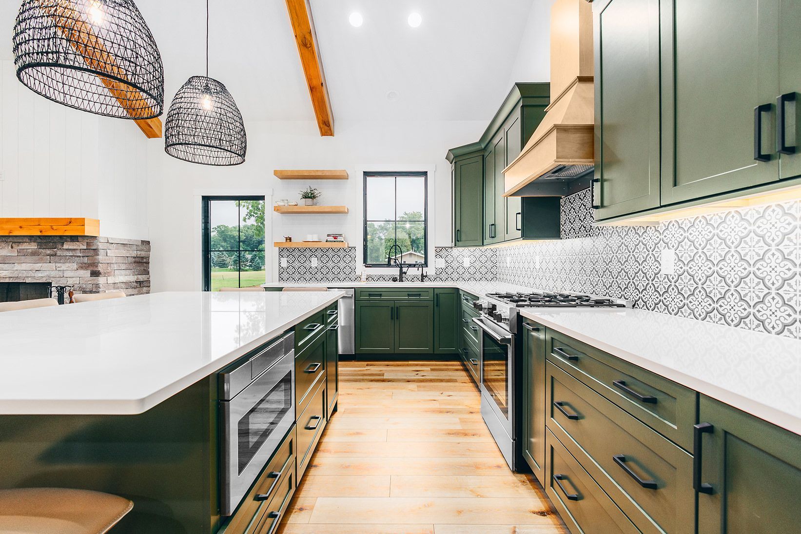 A kitchen with a wooden counter top , stove , oven , sink and window.