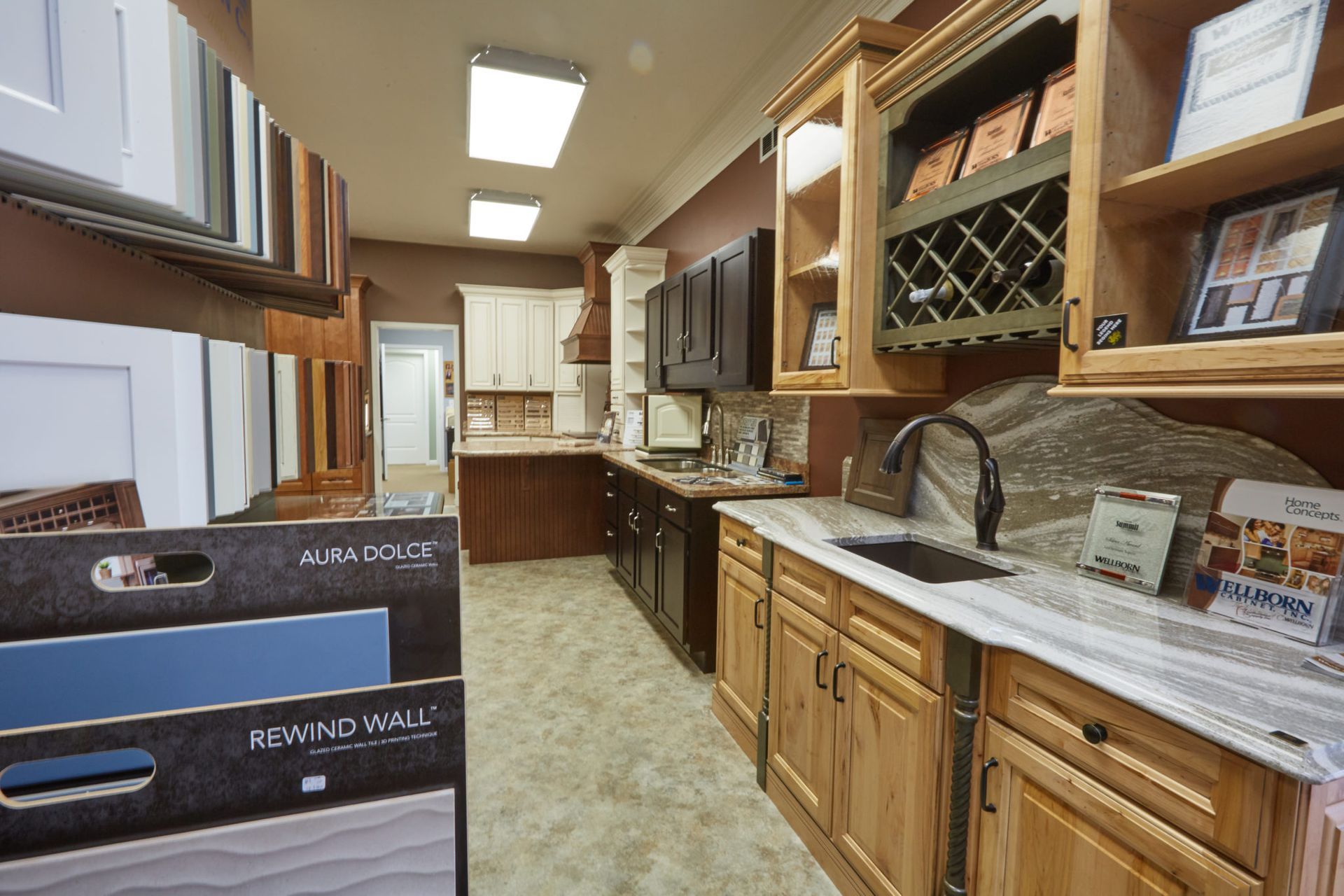 A kitchen with wooden cabinets and a sink in a showroom.