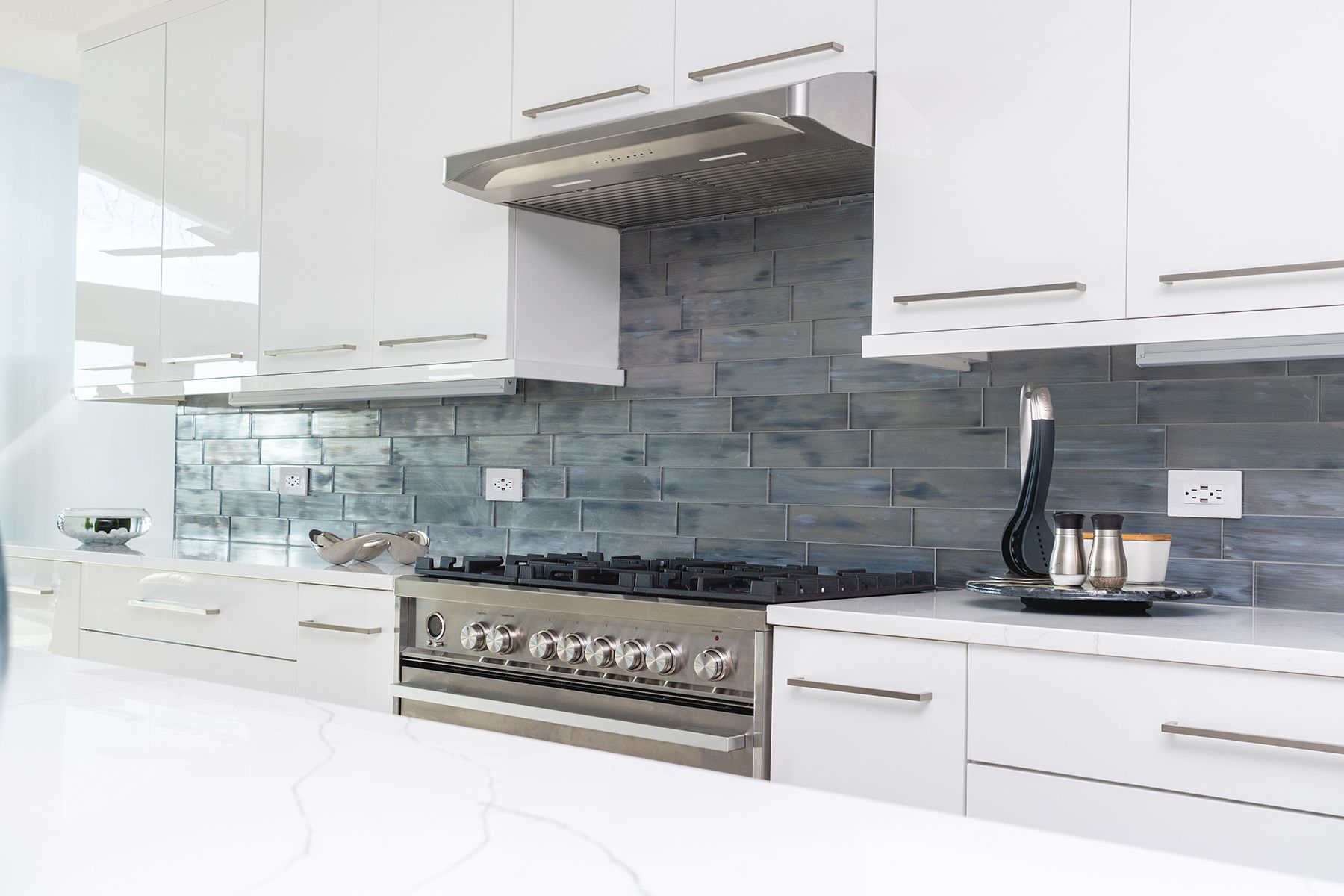 A kitchen with white cabinets and a stove top oven.