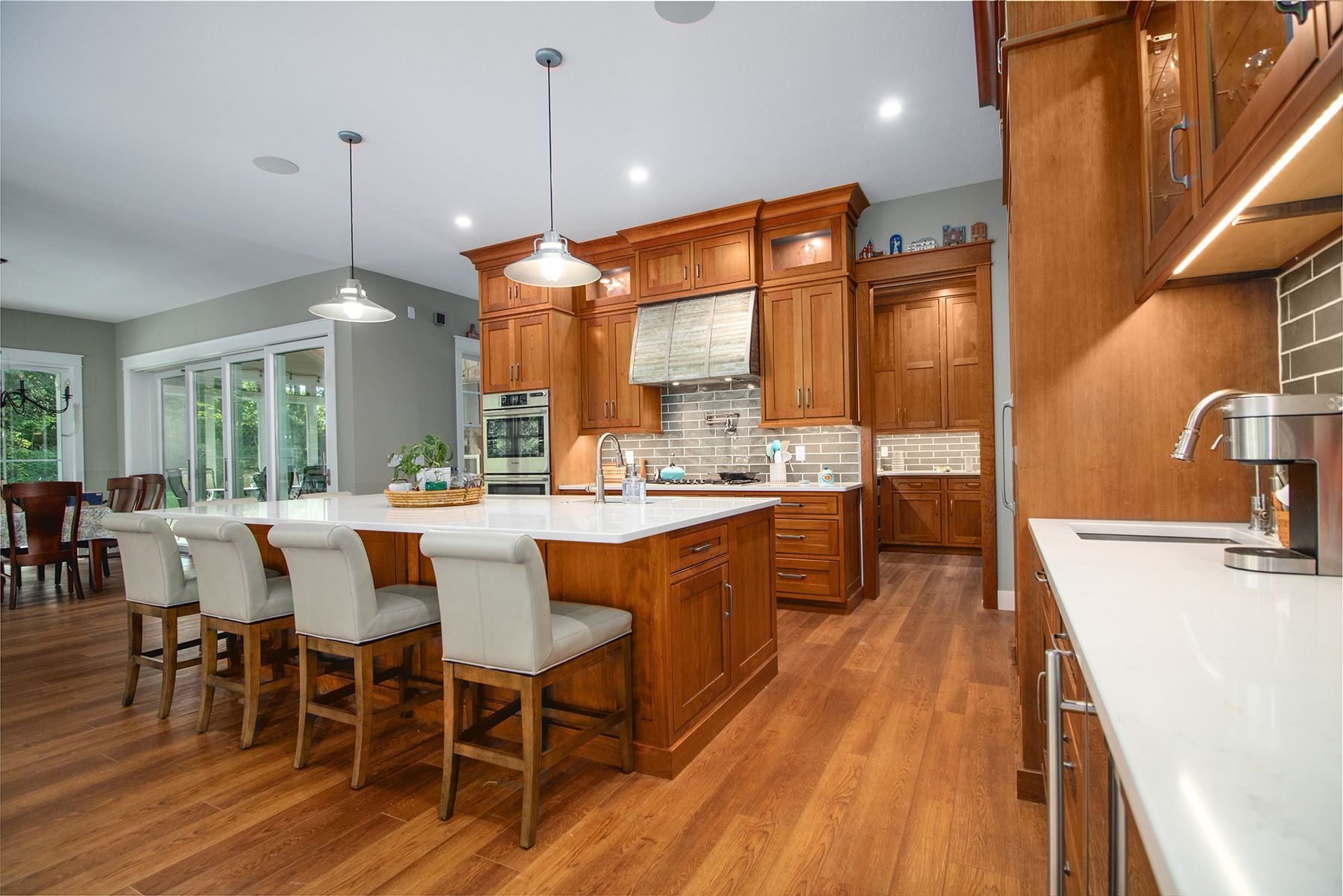 A kitchen with wooden cabinets , white counter tops , and a large island.