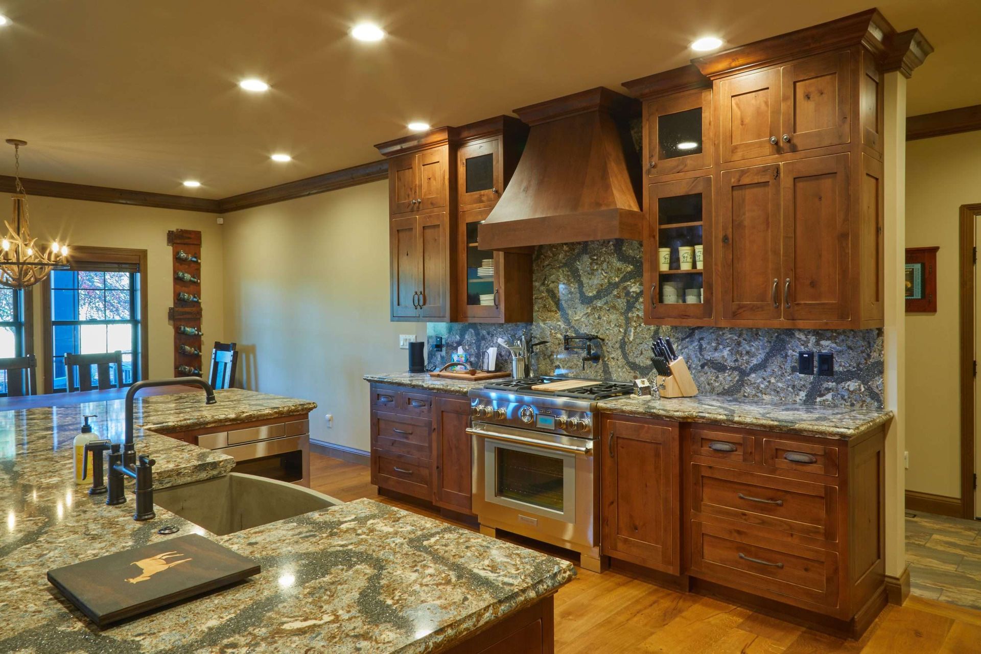 A kitchen with wooden cabinets , granite counter tops , stainless steel appliances and a large island.