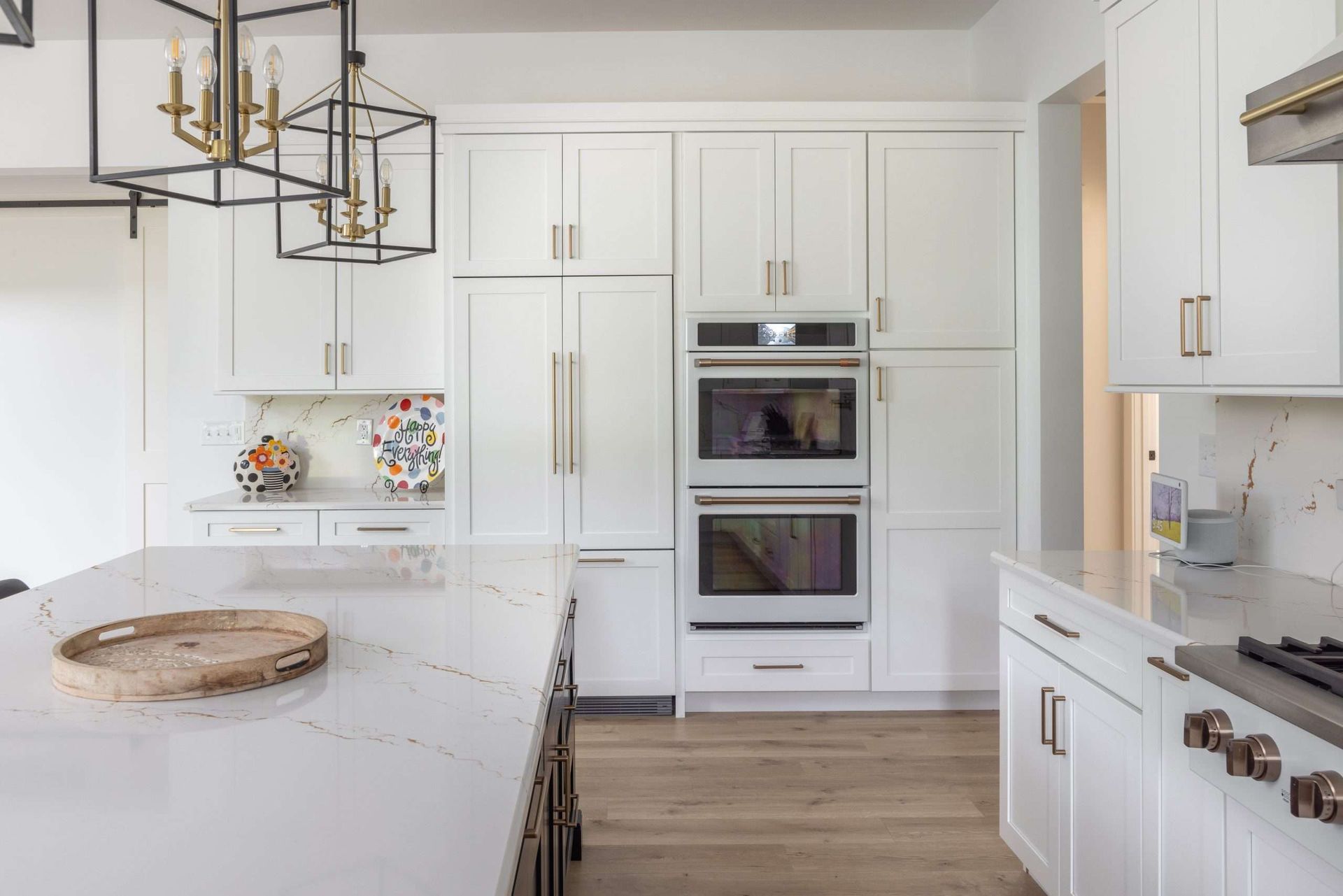 A kitchen with white cabinets , stainless steel appliances , and a large island.