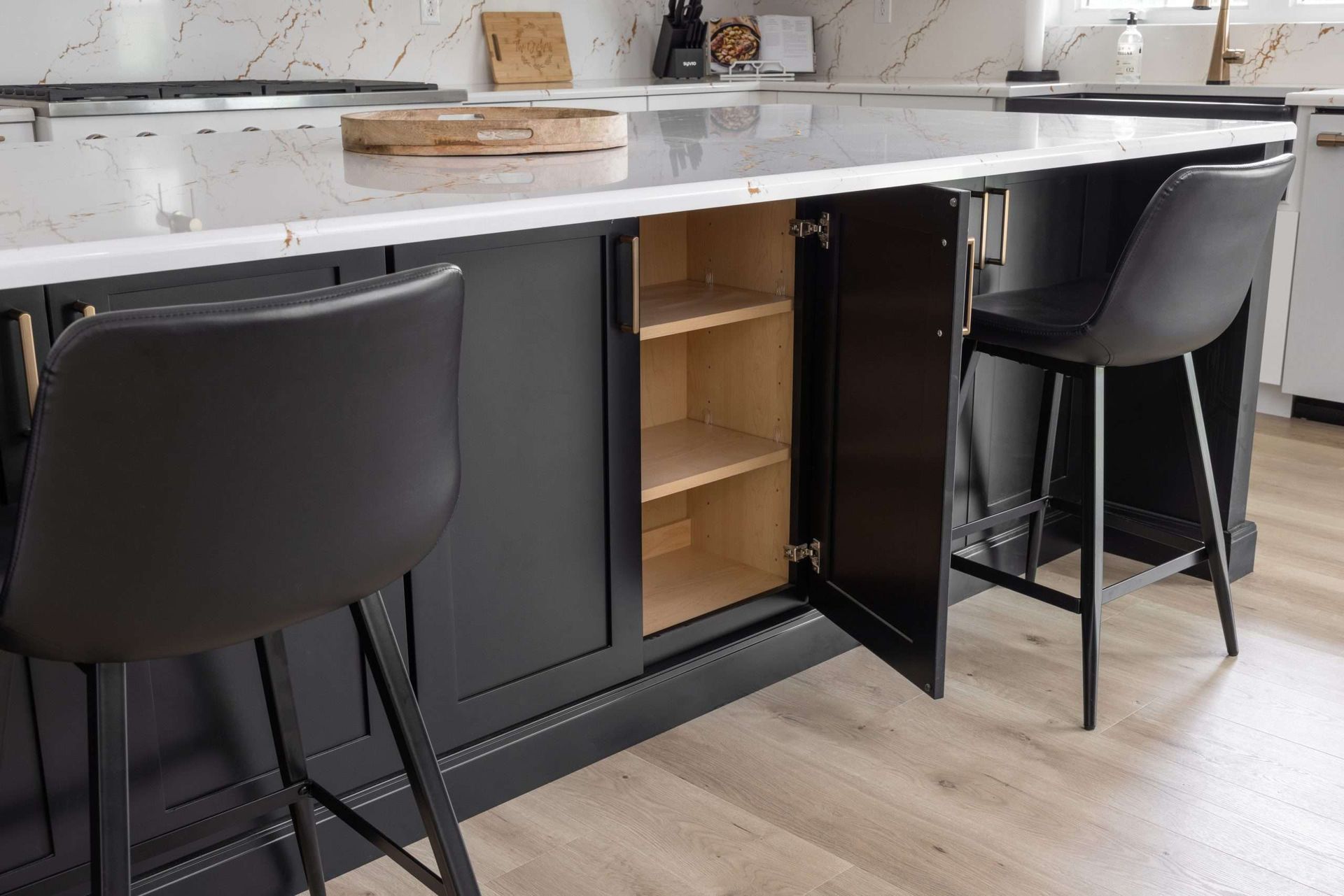 A kitchen with white cabinets , stainless steel appliances , and a large island.