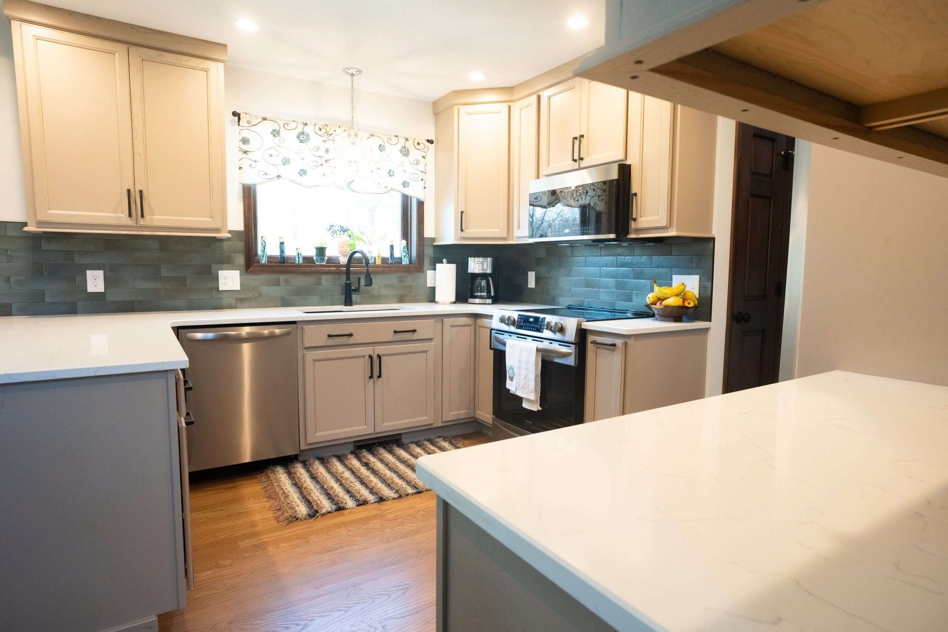 A kitchen with stainless steel appliances , white cabinets , and a large island.