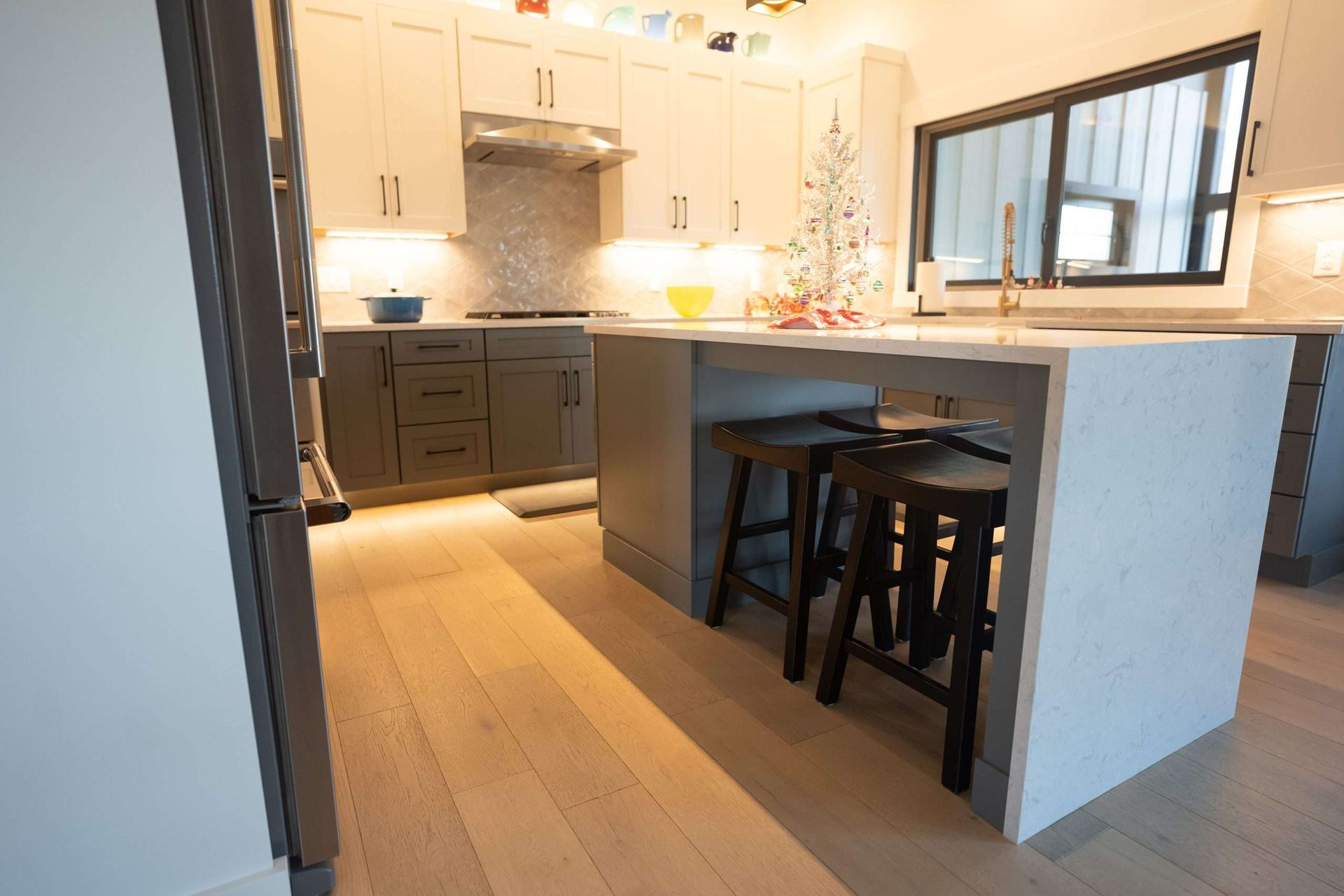 A kitchen with wooden cabinets , white counter tops , and a large island.