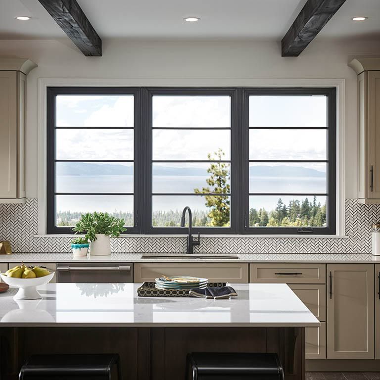 A kitchen with a large window over the sink and a large island.