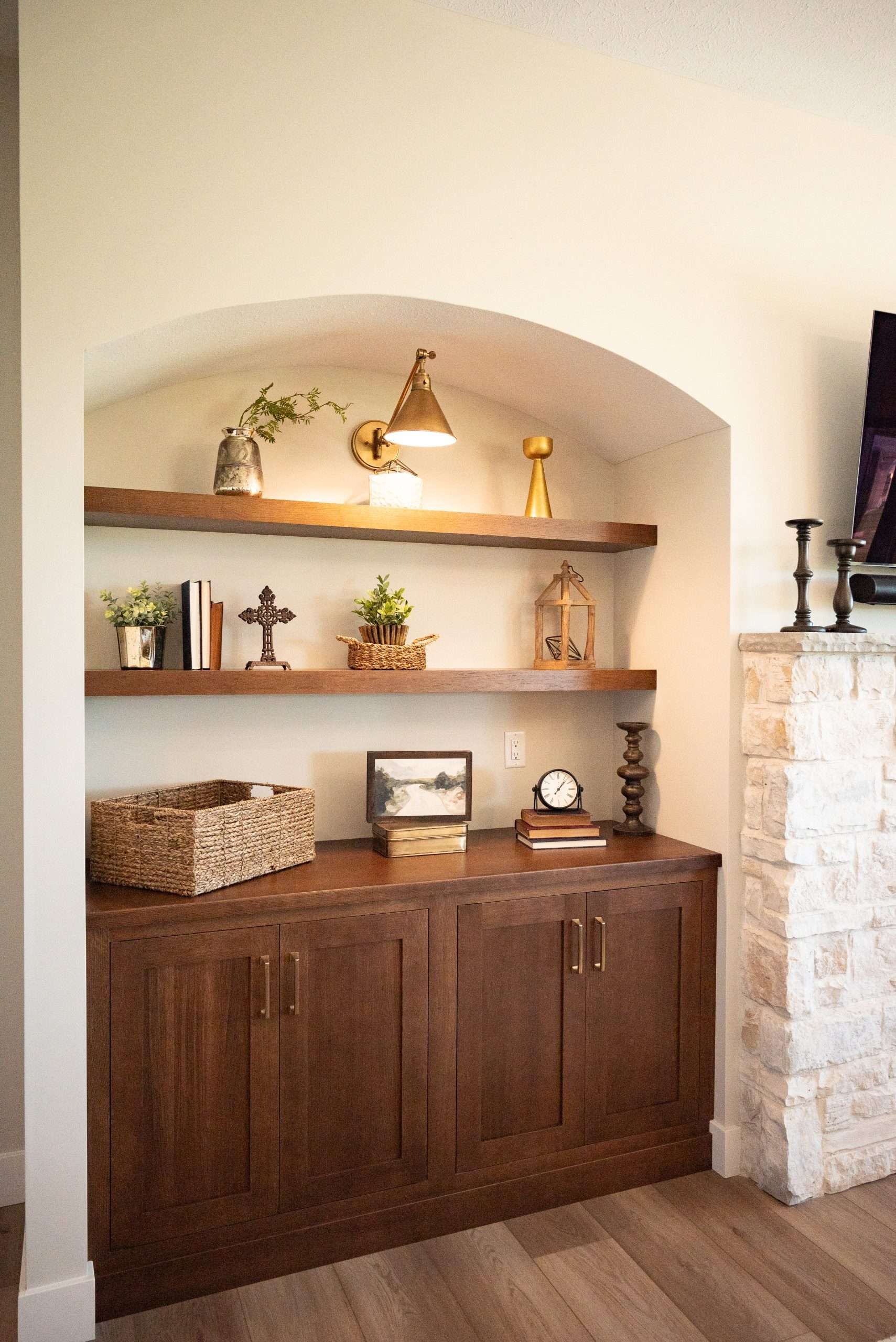 A living room with a fireplace , wooden cabinets and shelves.