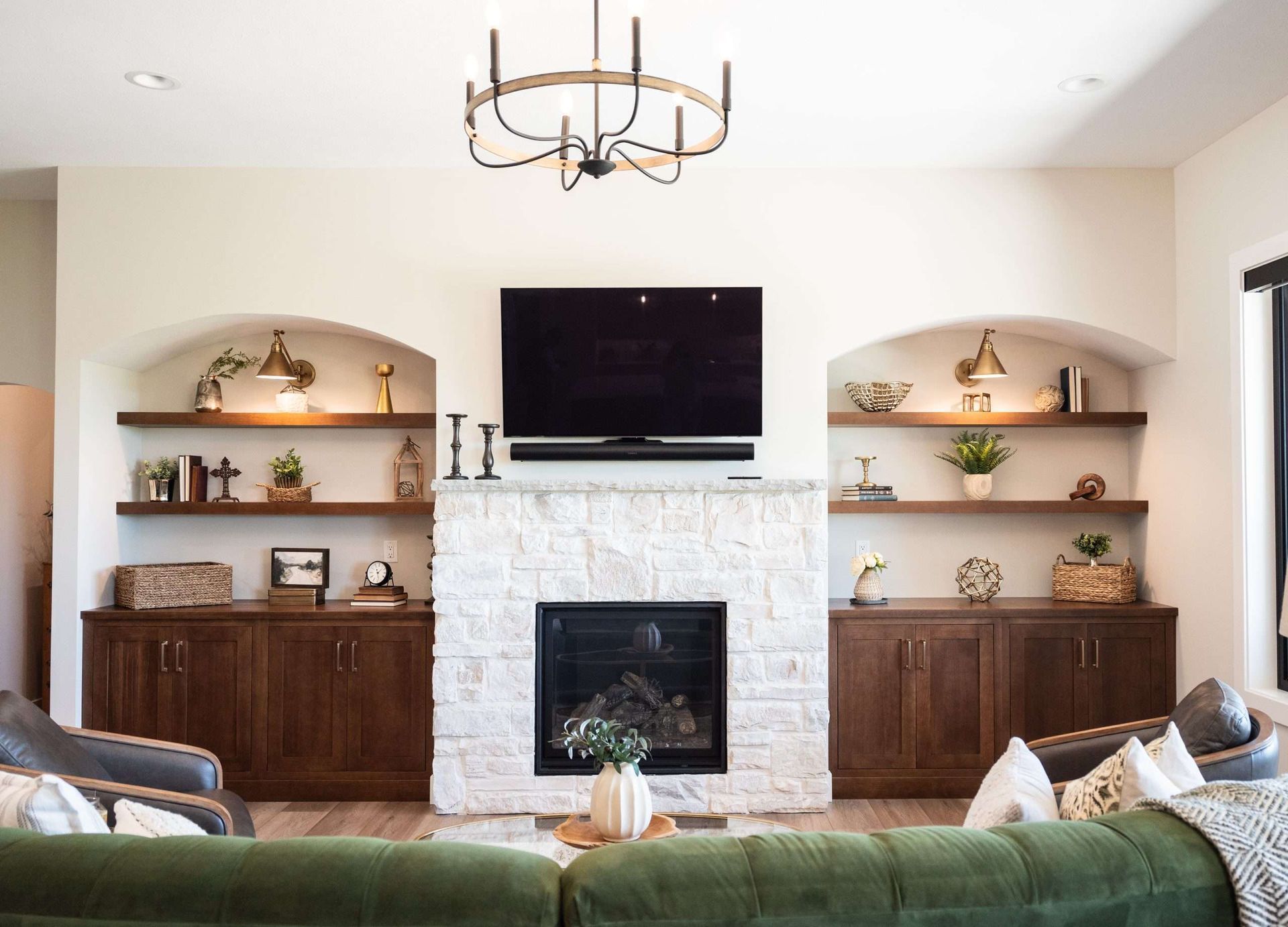 A living room with a fireplace , couch , television and shelves.