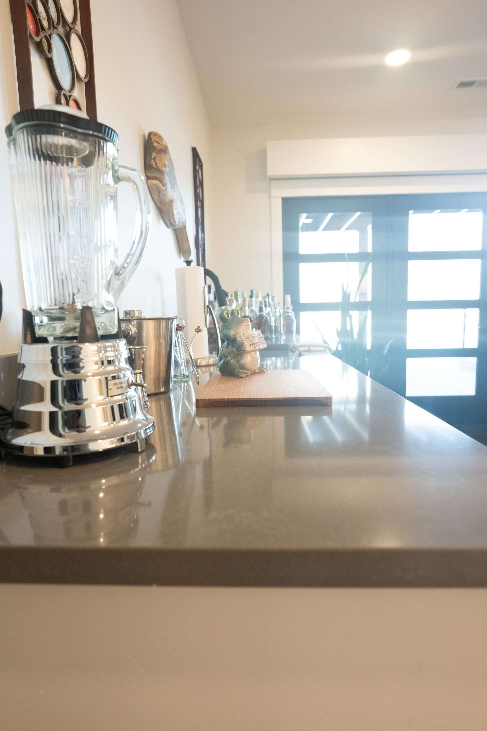 A kitchen counter with a blender and a cutting board on it.
