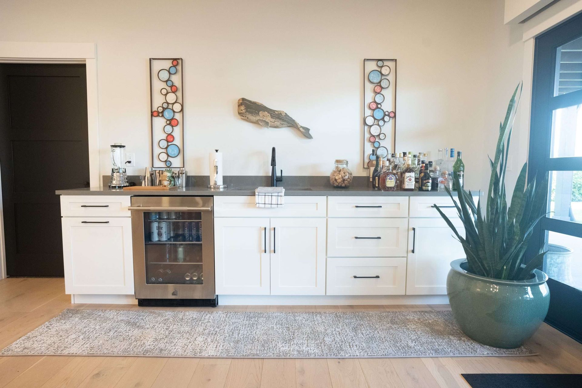 A kitchen with white cabinets and a stainless steel refrigerator.