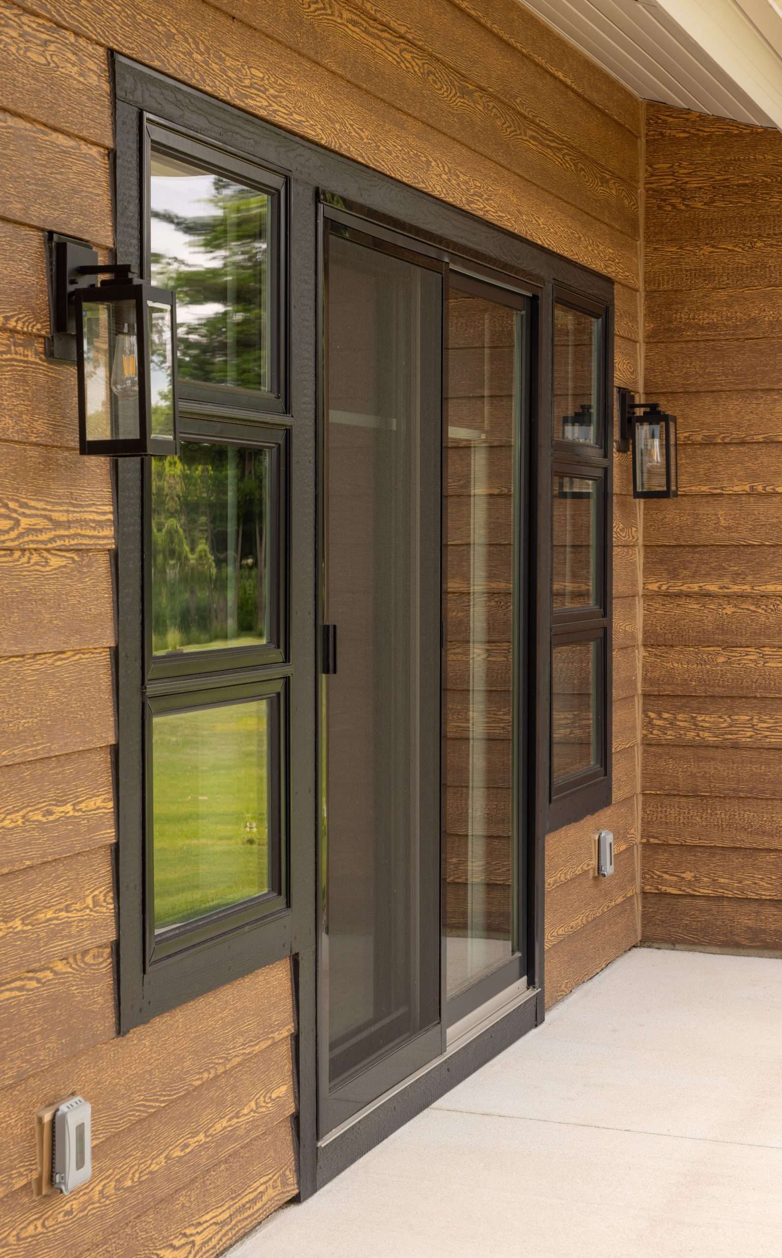 A house with a sliding glass door and two windows.