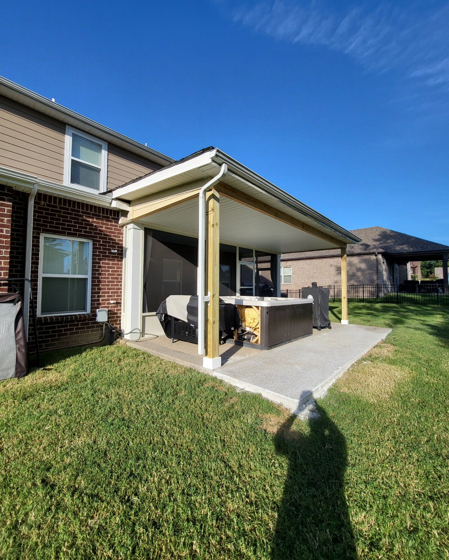 Screened-in porch addition with wood framing, attached to a brick home. Includes screens, lattice, and a gable roof.