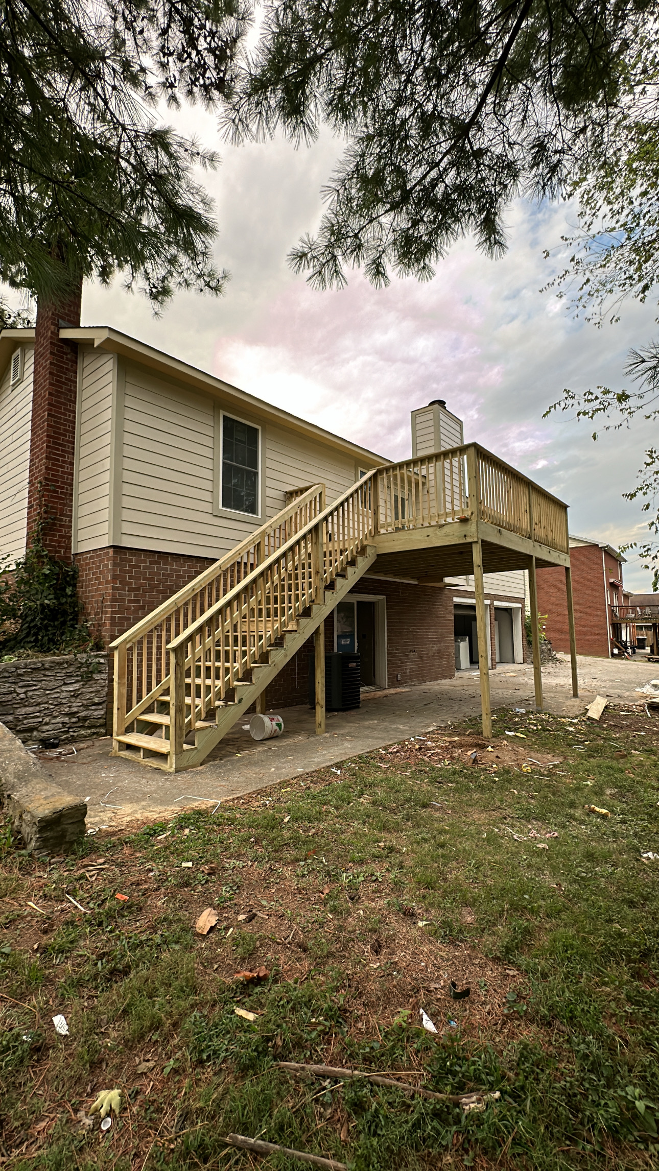 Empty, freshly painted living room with recessed lighting and wood-look flooring. Doors lead to other rooms.