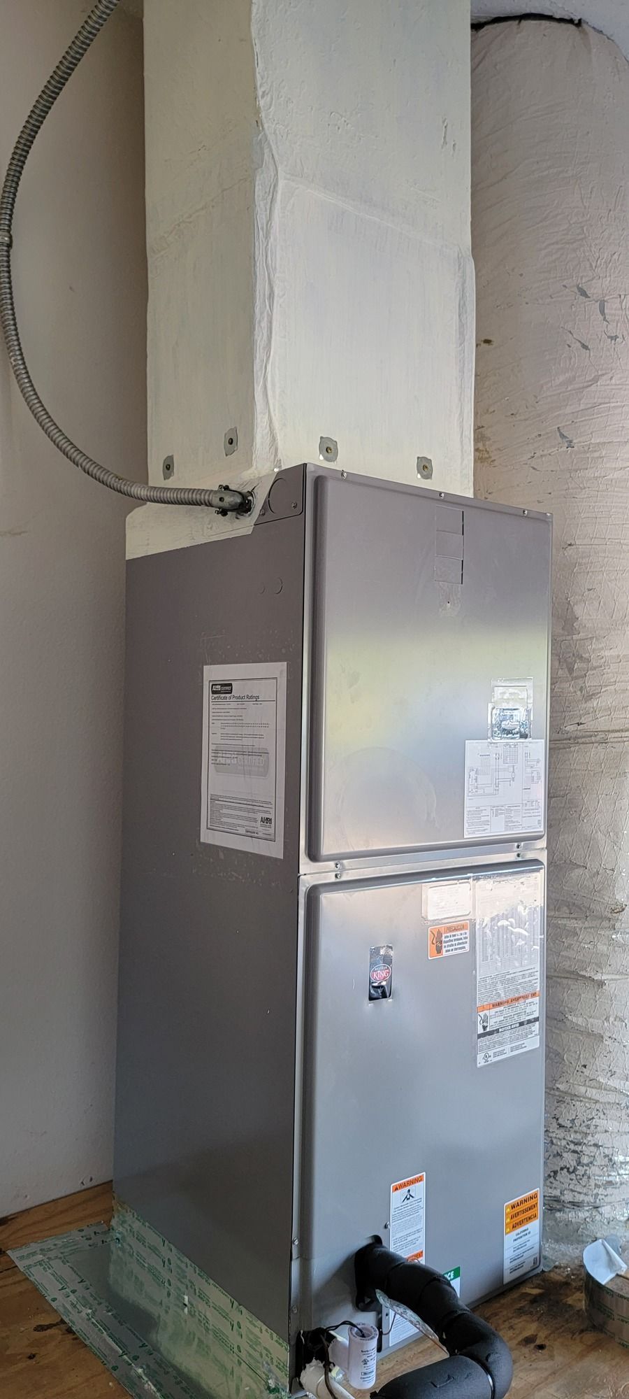 A refrigerator is sitting next to a heater in a room.