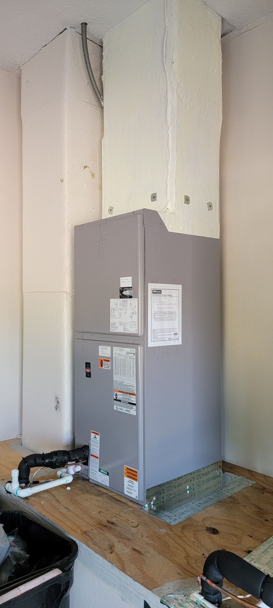 A refrigerator is sitting on top of a wooden floor in a room.