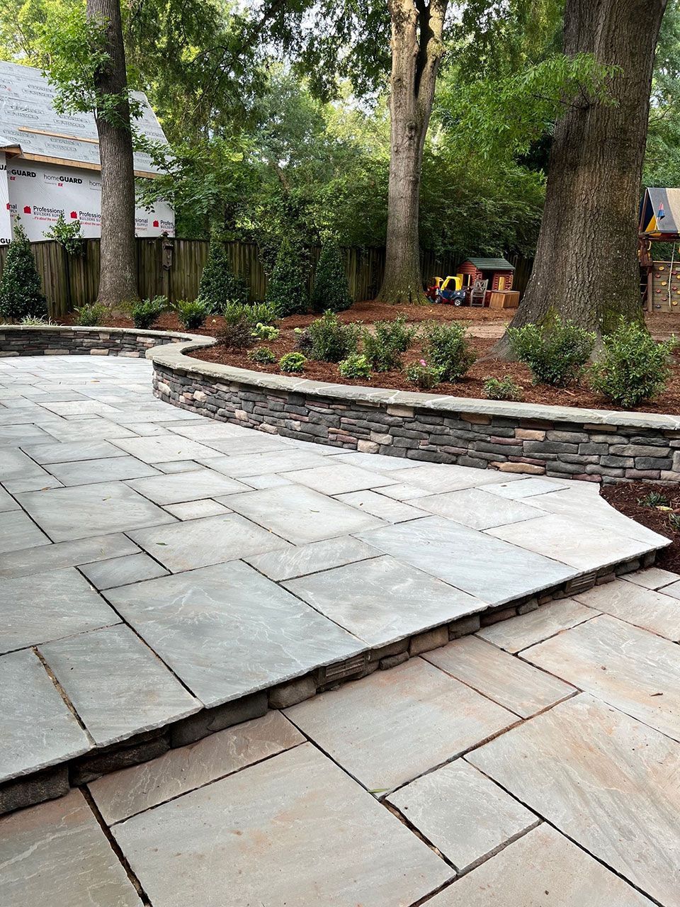 Backyard landscape installation service of retaining wall garden bed from Brookscapes LLC