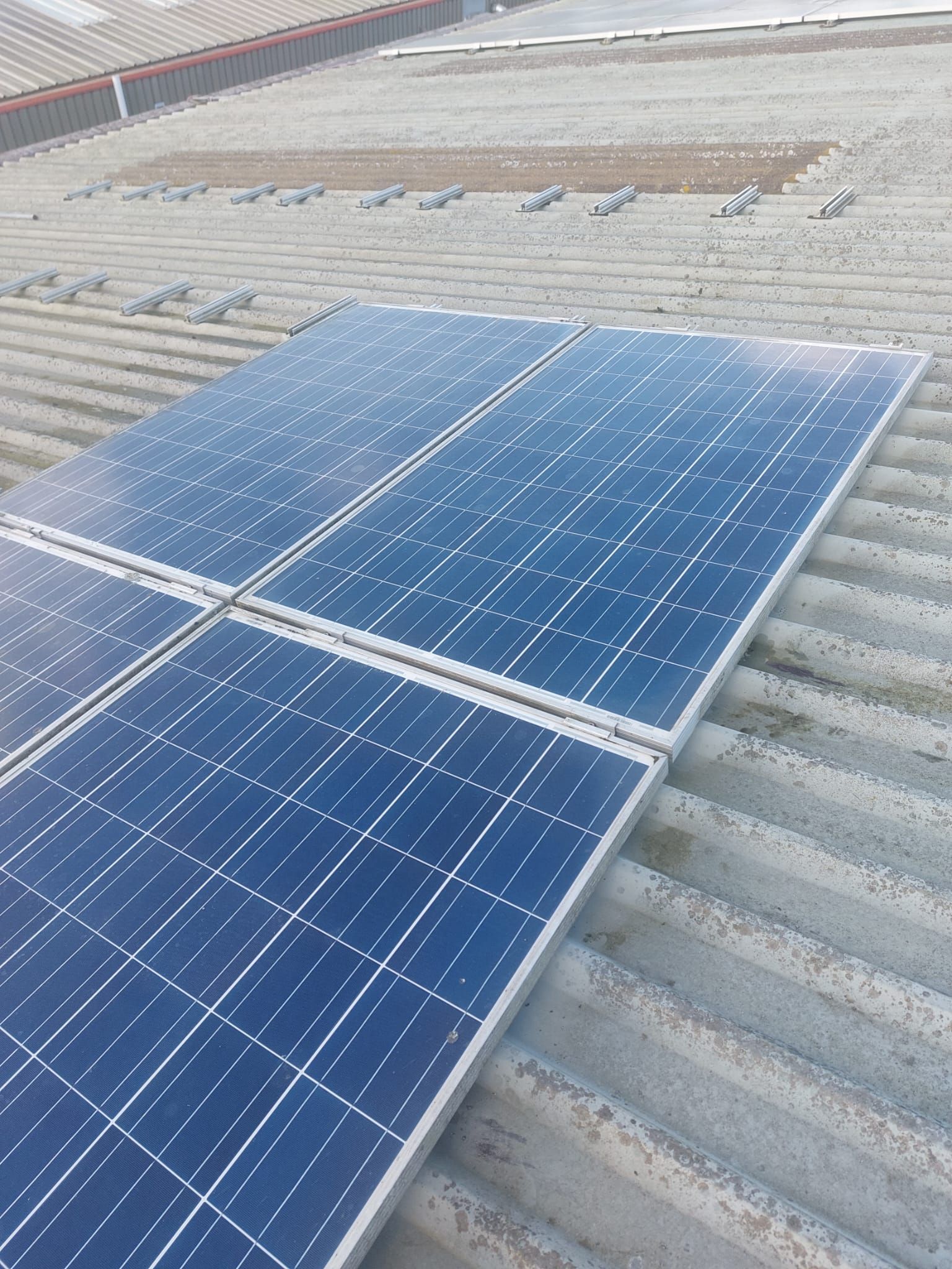 A row of solar panels sitting on top of a roof.