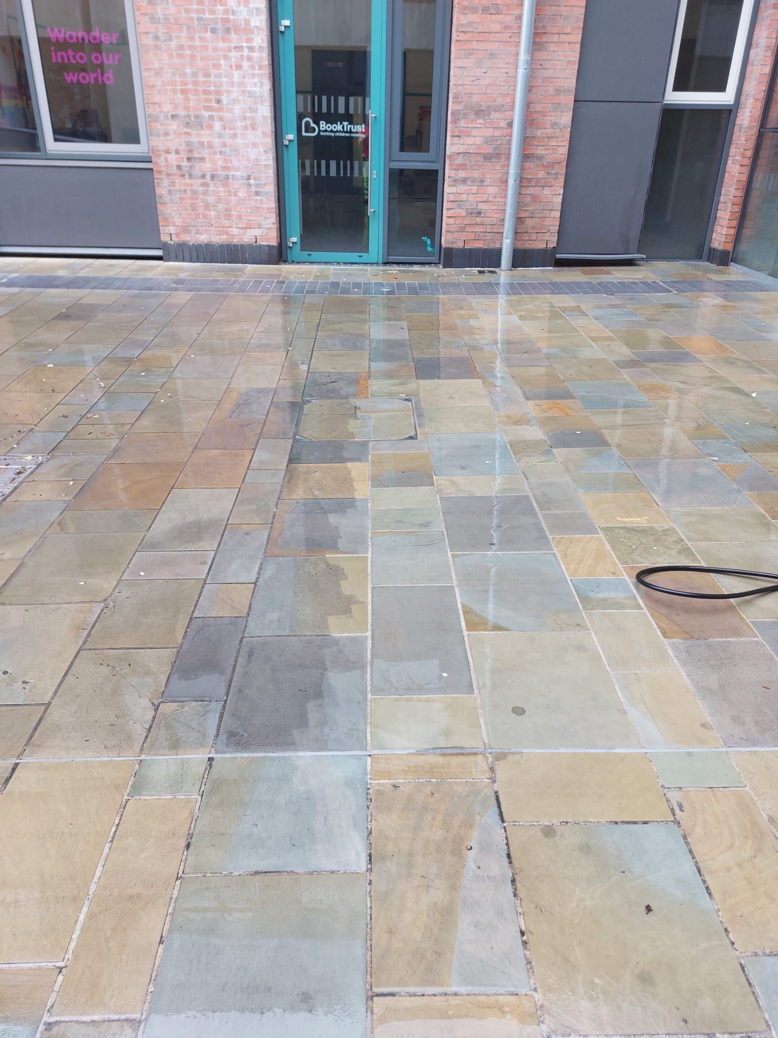 A brick building with a green door and a brick walkway