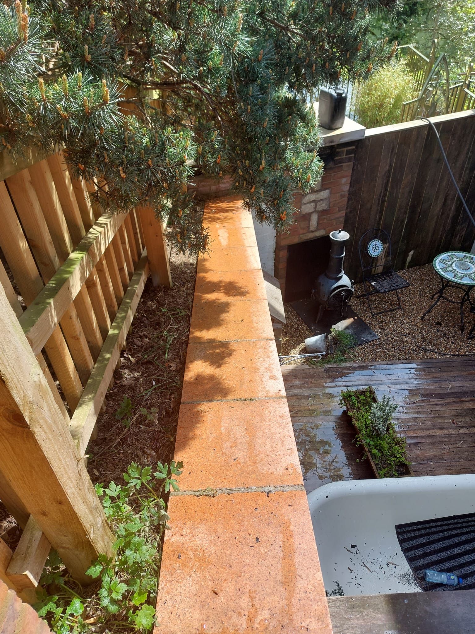 An aerial view of a backyard with a brick wall and a wooden fence.