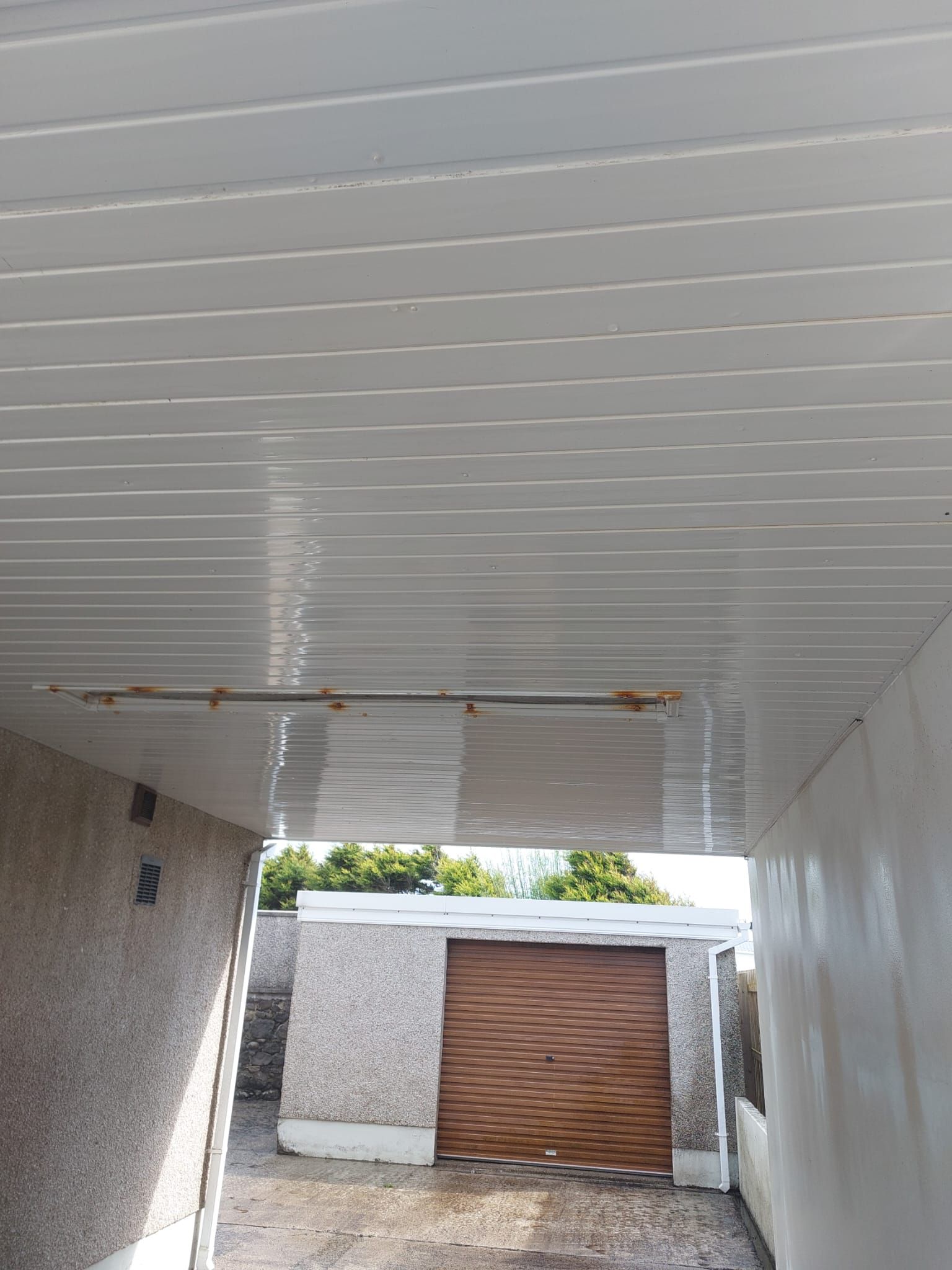 A garage with a white ceiling and a wooden door.
