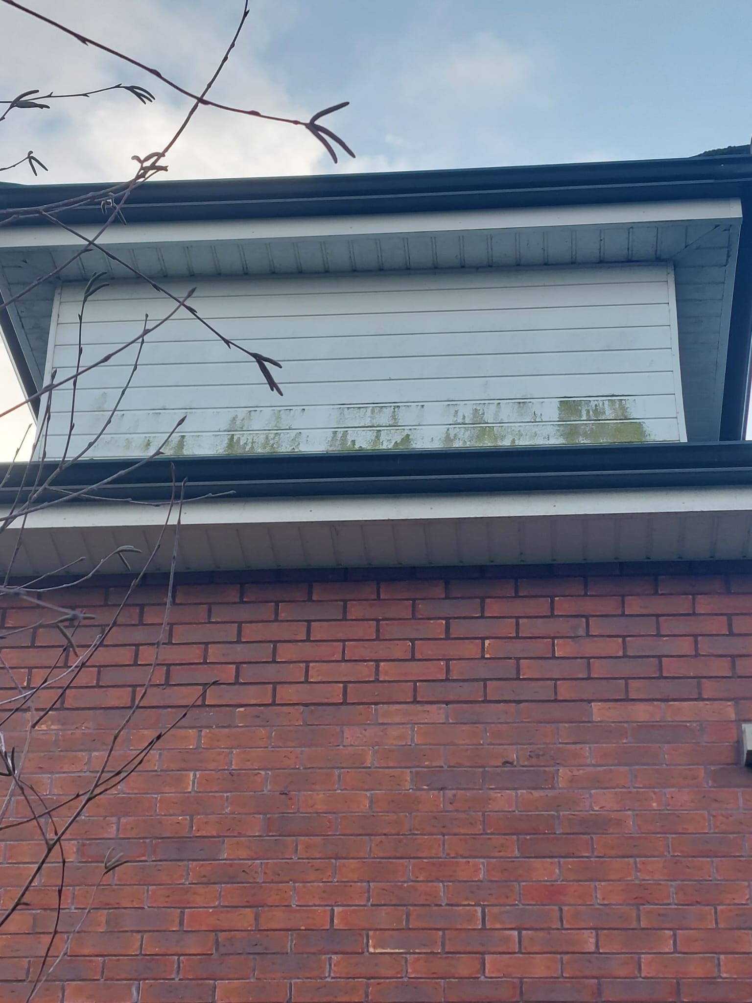 A brick building with a white roof and a window