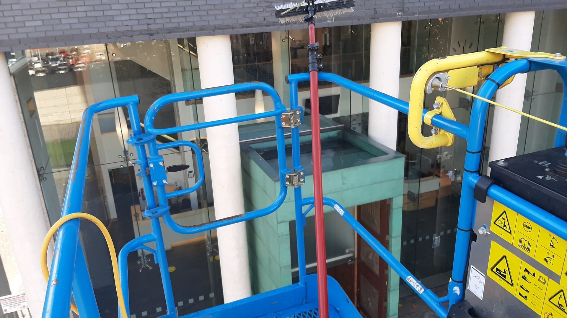 A person is standing on a lift in front of a building.