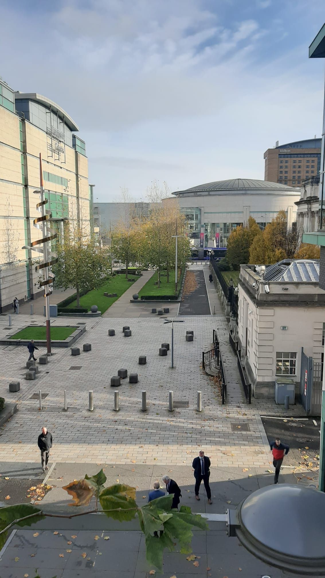 A group of people are walking down a sidewalk in a city.