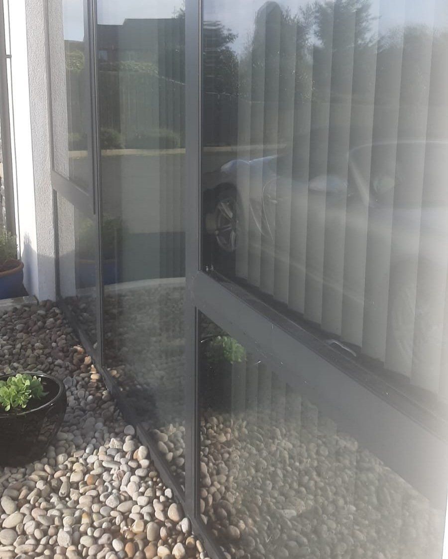 A close up of a window with a reflection of a car in it.